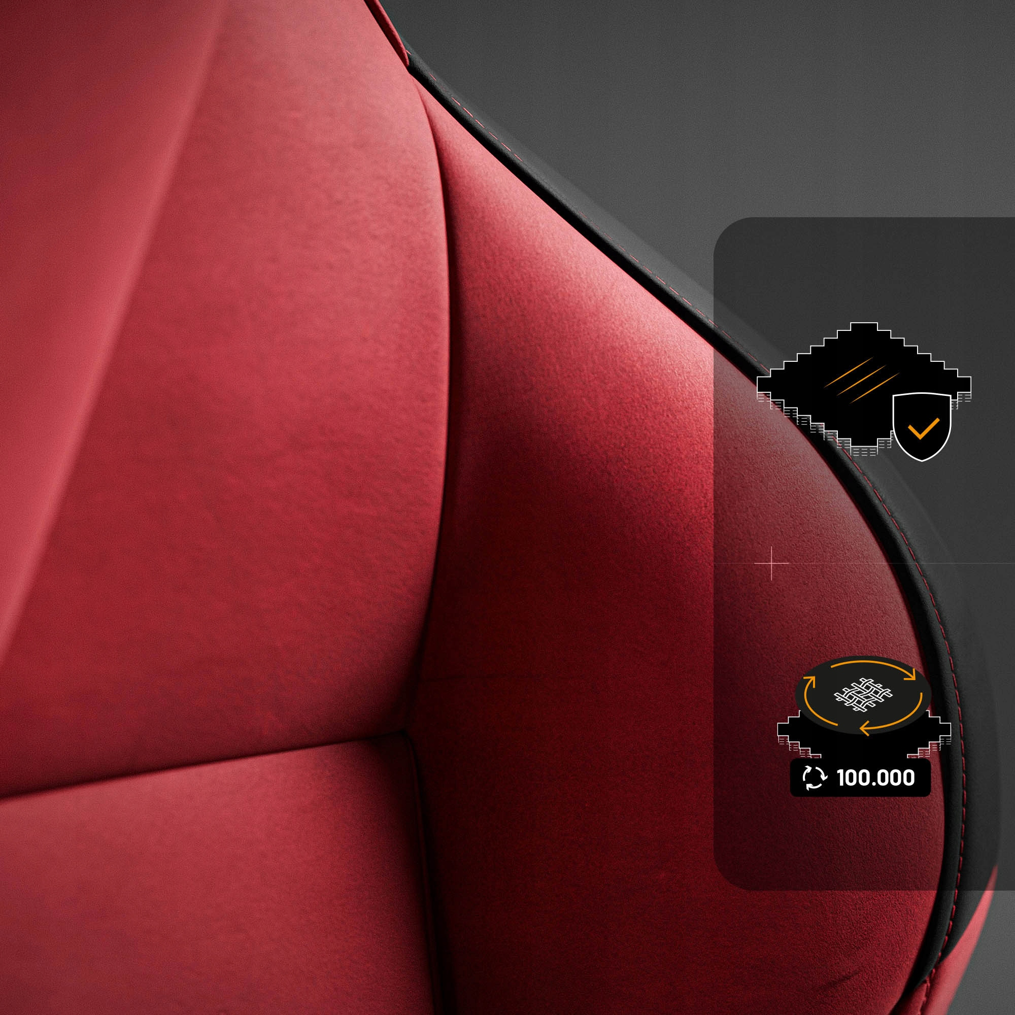 Zbliżenie czerwonego siedzenia samochodowego. Widoczne czarne akcenty, szwy oraz grafika z haczykiem i liczbą 100 000.