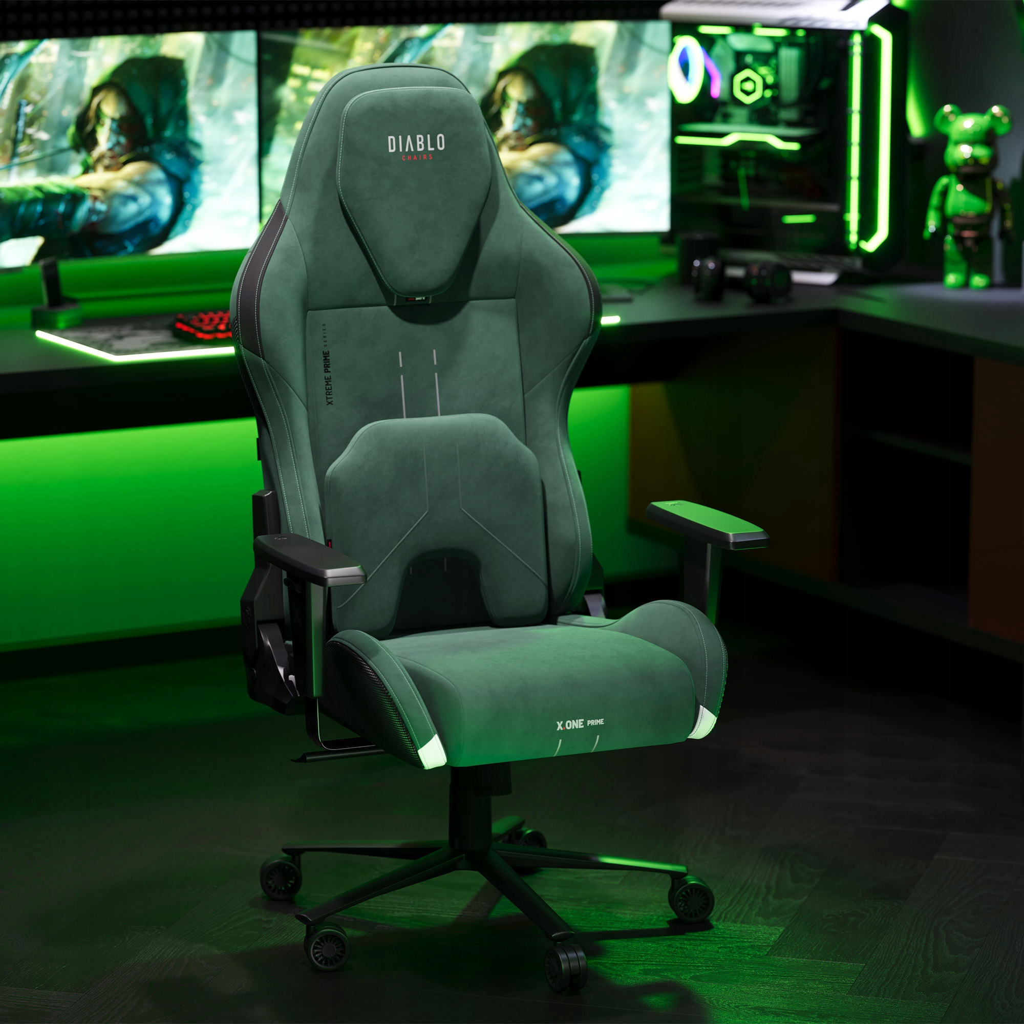 Zielony fotel gamingowy. Logo Diablo na zagłówku, X One Prime na siedzisku. Monitory i PC w tle. Zielone oświetlenie.