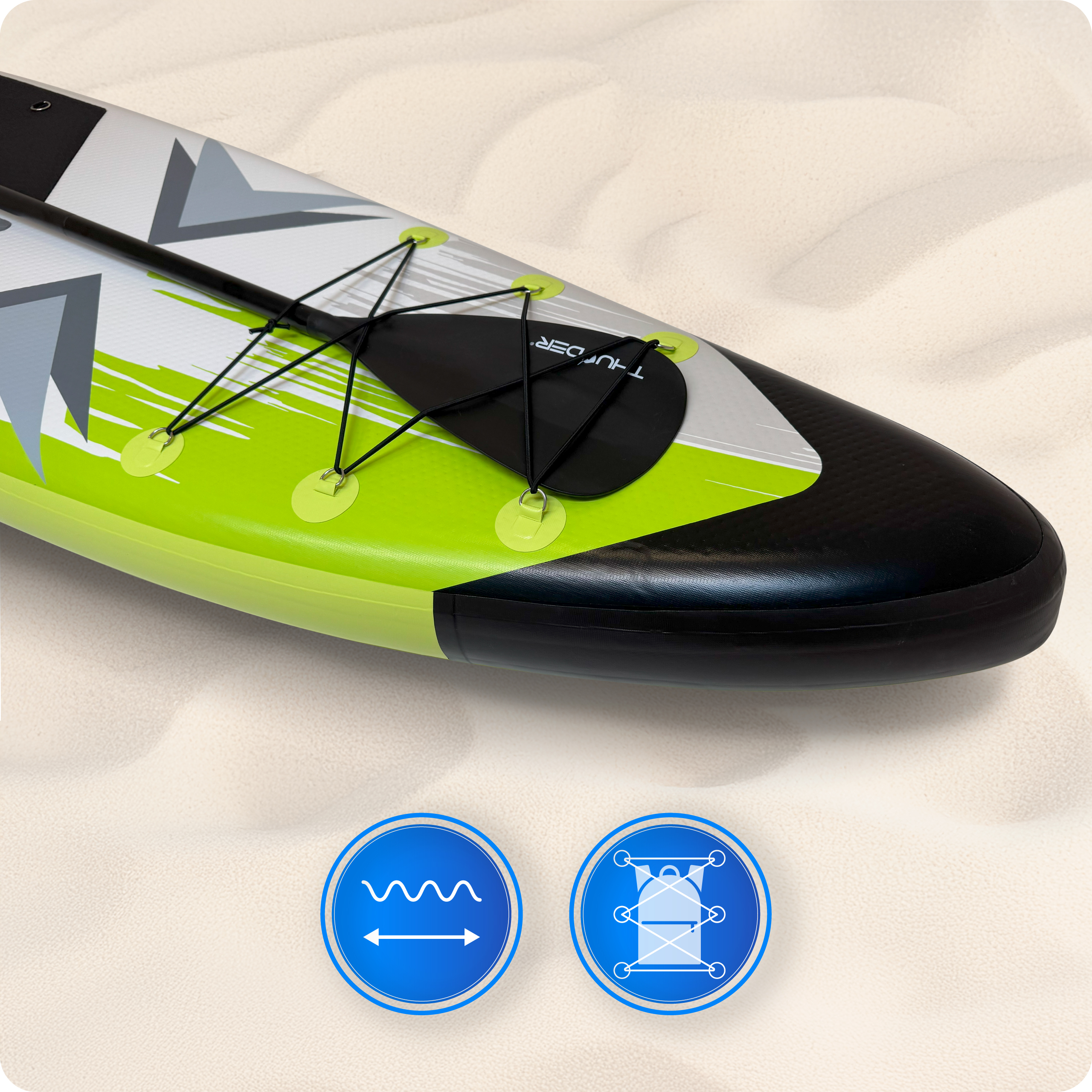 Zielona i czarna deska do wiosłowania na piasku. Widoczne wiosło i sznury. Dwa niebieskie okręgi z ikonami w rogu.