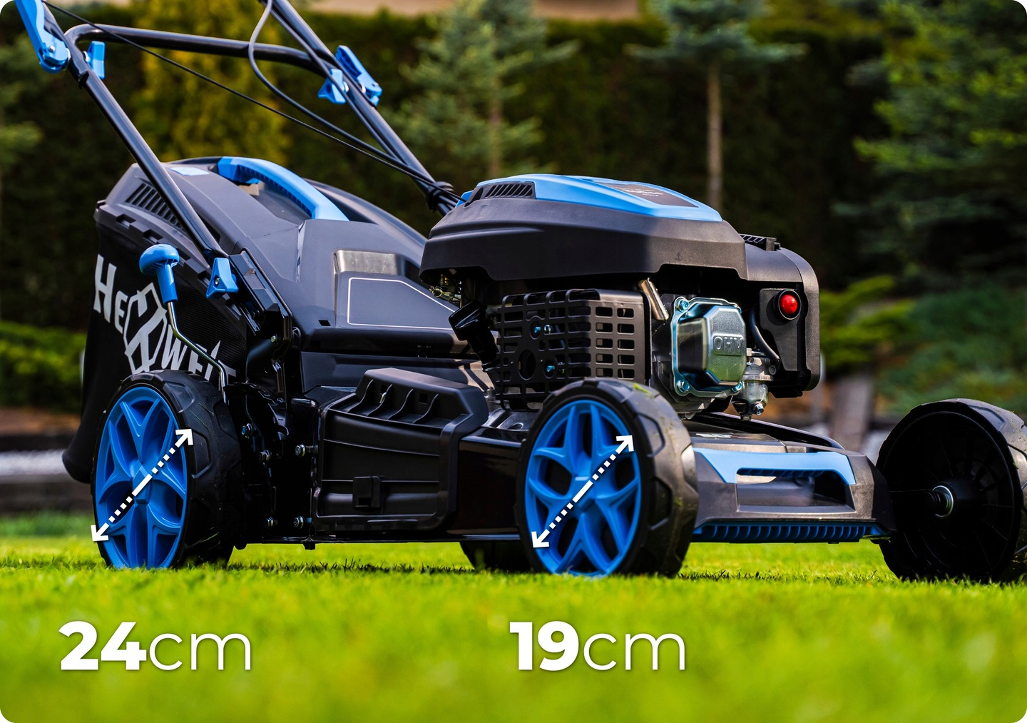 Kosiarka do trawy z niebieskimi kołami na zielonej trawie. Maszyna jest czarna i ma niebieski uchwyt. Tło to zielony trawnik i drzewa.