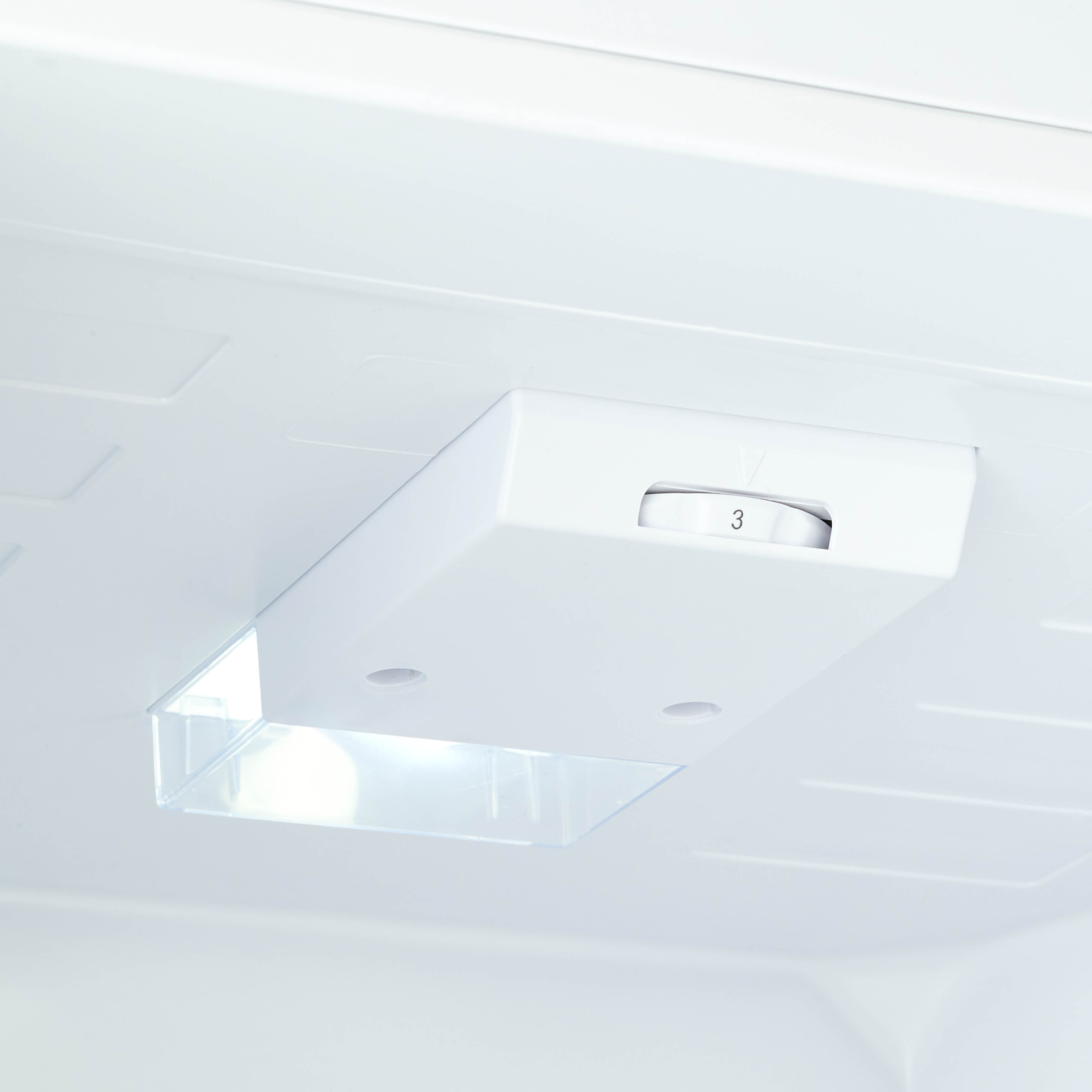 Binnenkant van een witte koelkast. Een bedieningspaneel met nummer 3 is zichtbaar. Zachte verlichting creëert schaduwen.