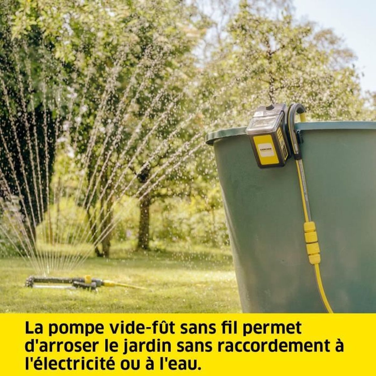 Una bomba inalámbrica rocía agua en un jardín. Un barril verde y árboles forman el fondo. La bomba es amarilla y negra.