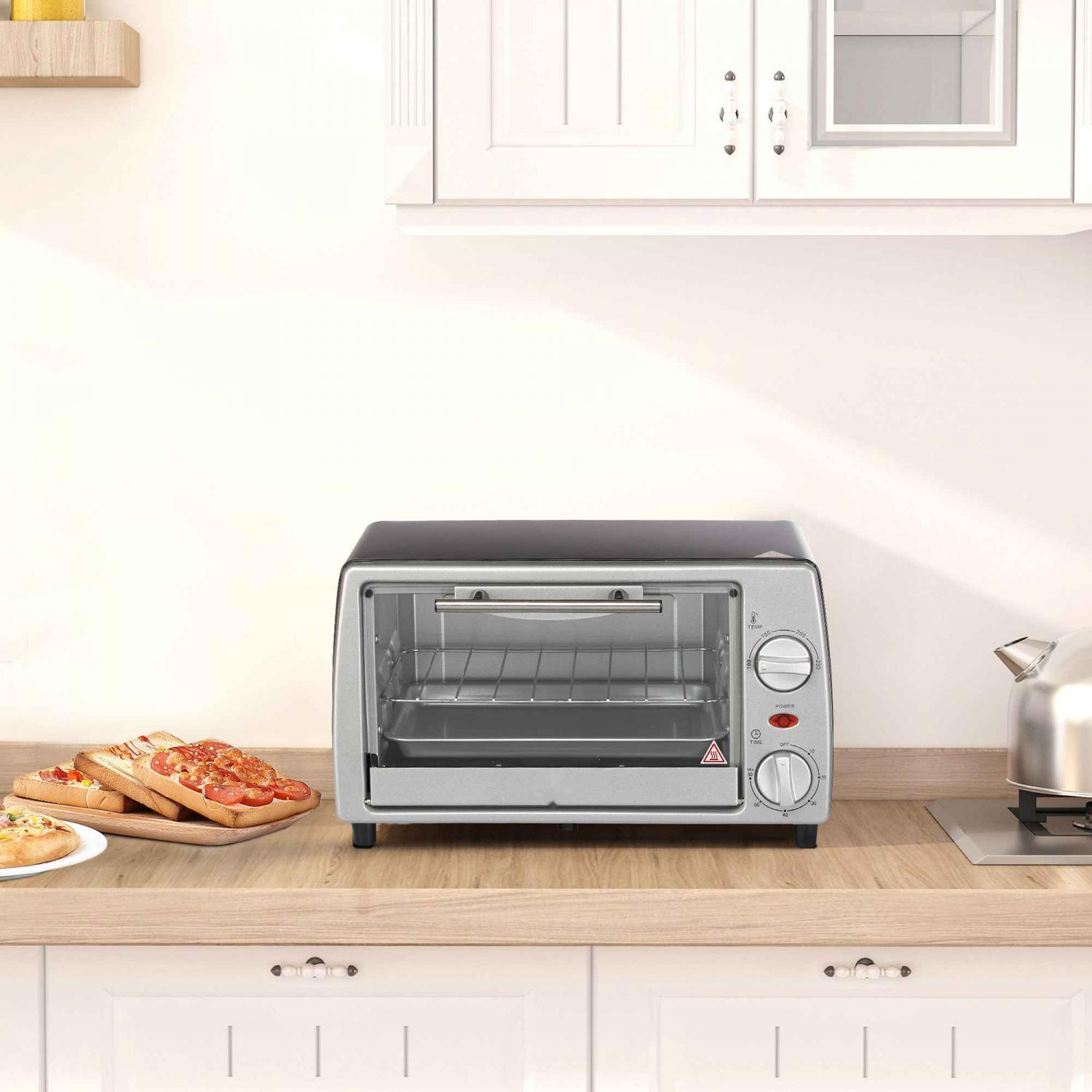 Ein Toaster steht auf einer Holztheke mit Sandwiches. Rechts ist ein Teekessel zu sehen. Im Hintergrund befinden sich weiße Schränke.