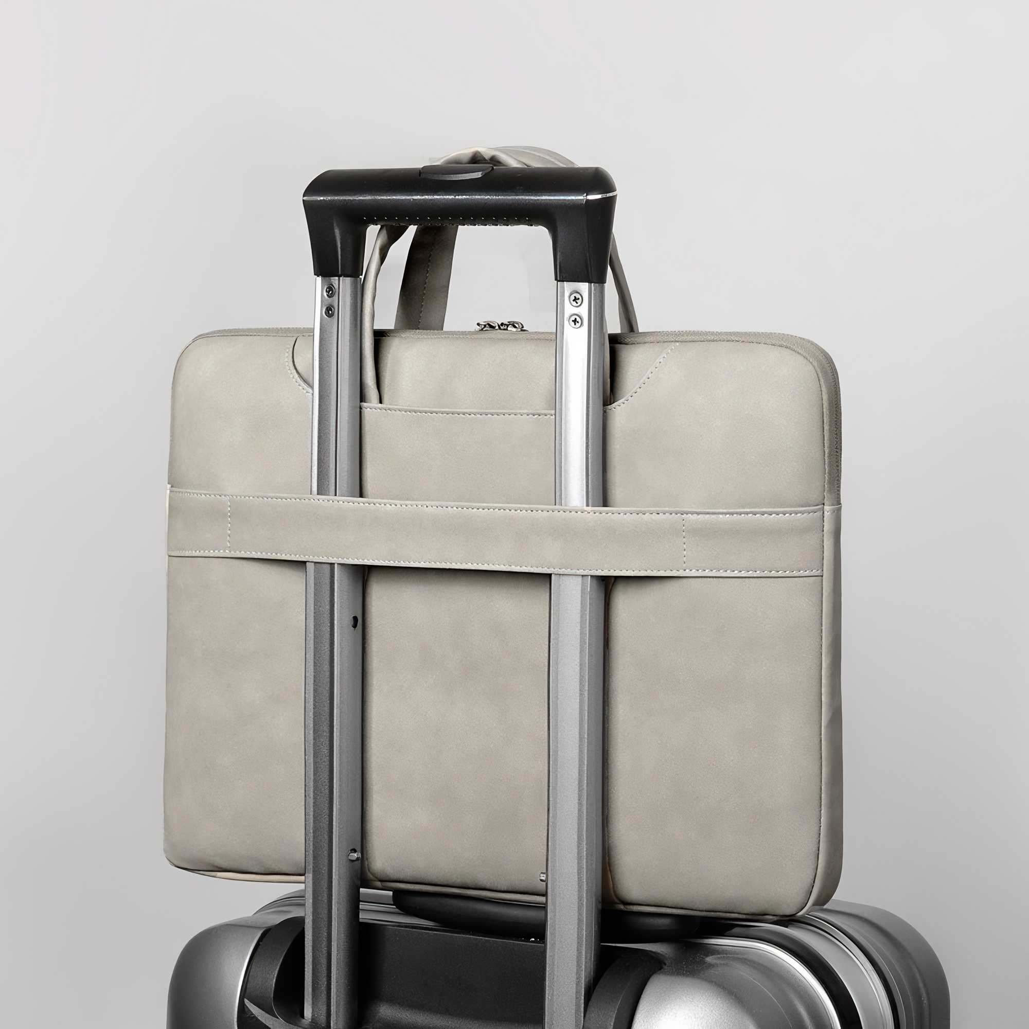 Eine hellgraue Laptoptasche ist auf einem Rollkoffer befestigt. Der Koffer hat den Griff ausgezogen.