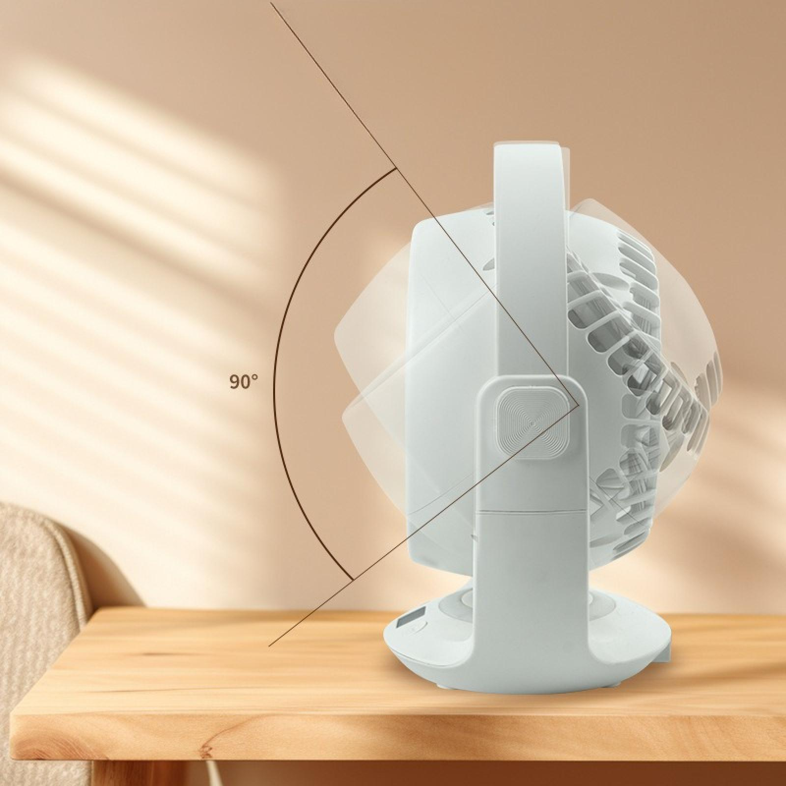 Ein weißer Tischventilator auf einem Holztisch mit einem 90-Grad-Winkelanzeiger. Der Hintergrund ist eine beige Wand und ein Teil eines Stuhls.