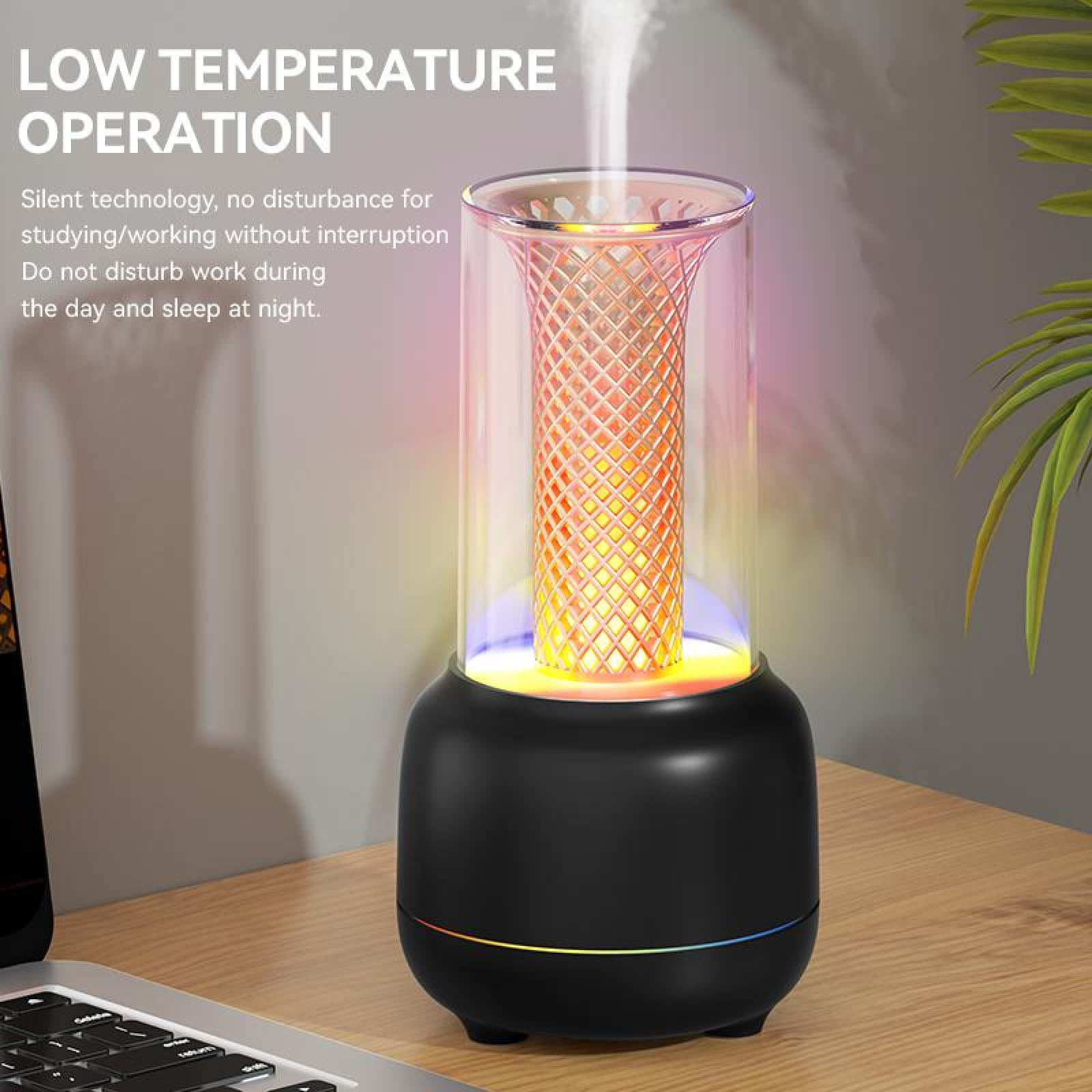 Ein schwarzer Diffusor mit farbigem Licht im Inneren, der Dampf abgibt. Er steht auf einem Holztisch mit einem Laptop und einer Pflanze im Hintergrund.