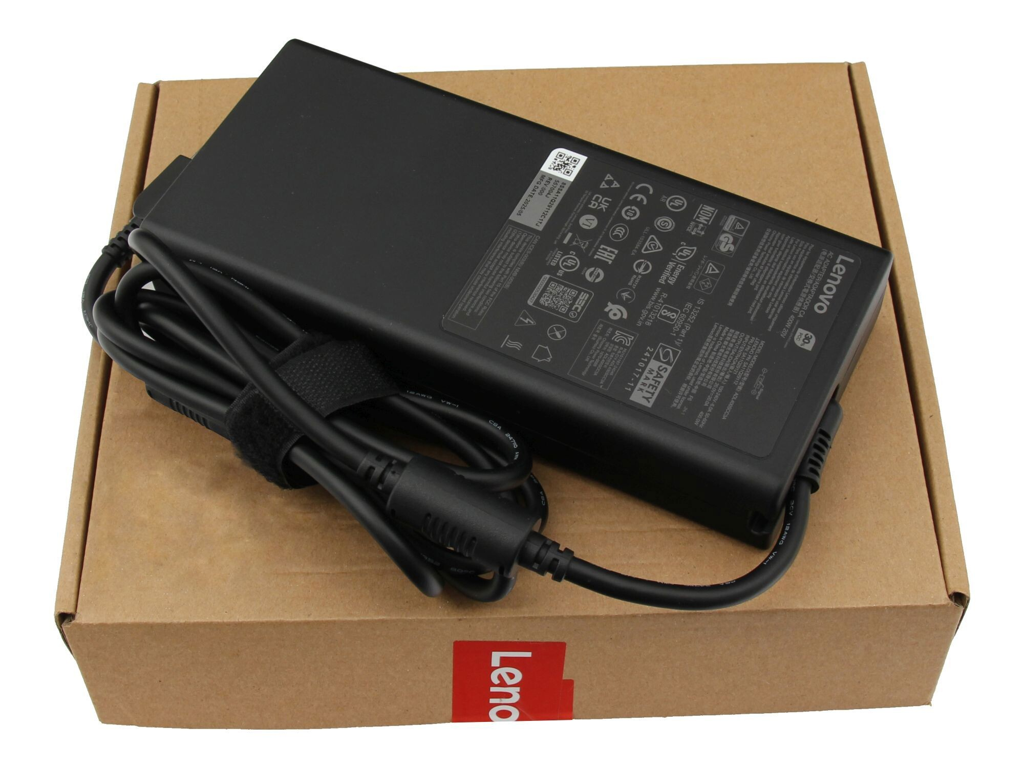 Schwarzes Lenovo Laptop-Netzteil auf einem Karton, mit dem Lenovo-Logo sichtbar.