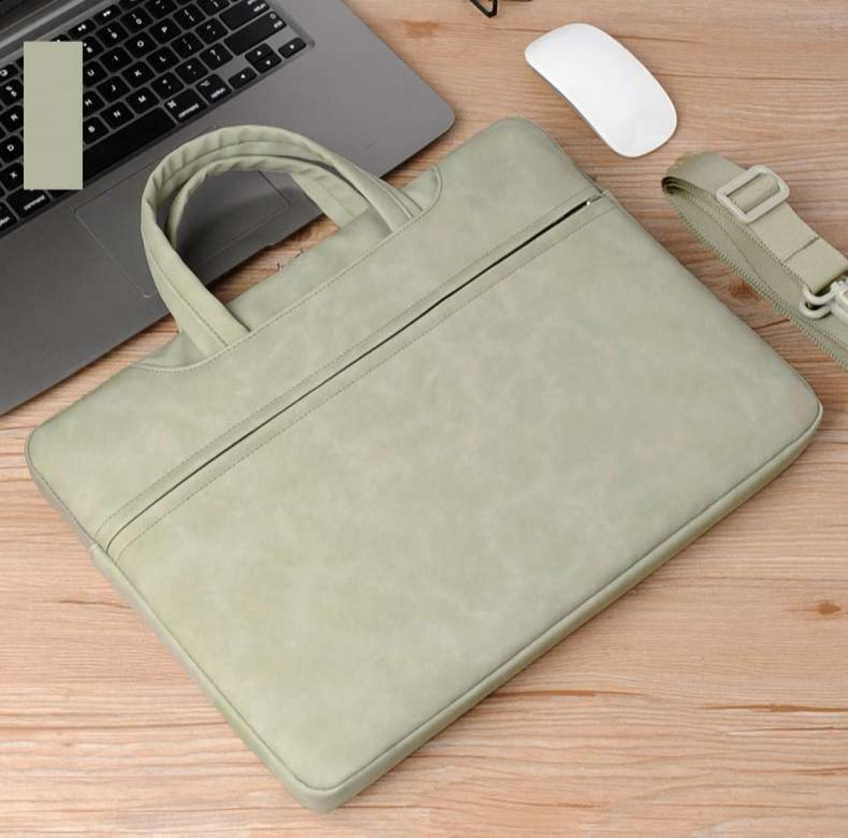 Eine hellgrüne Laptoptasche mit Griffen, Reißverschluss und Riemen. Daneben ein Laptop, eine weiße Maus und Holzoberfläche.