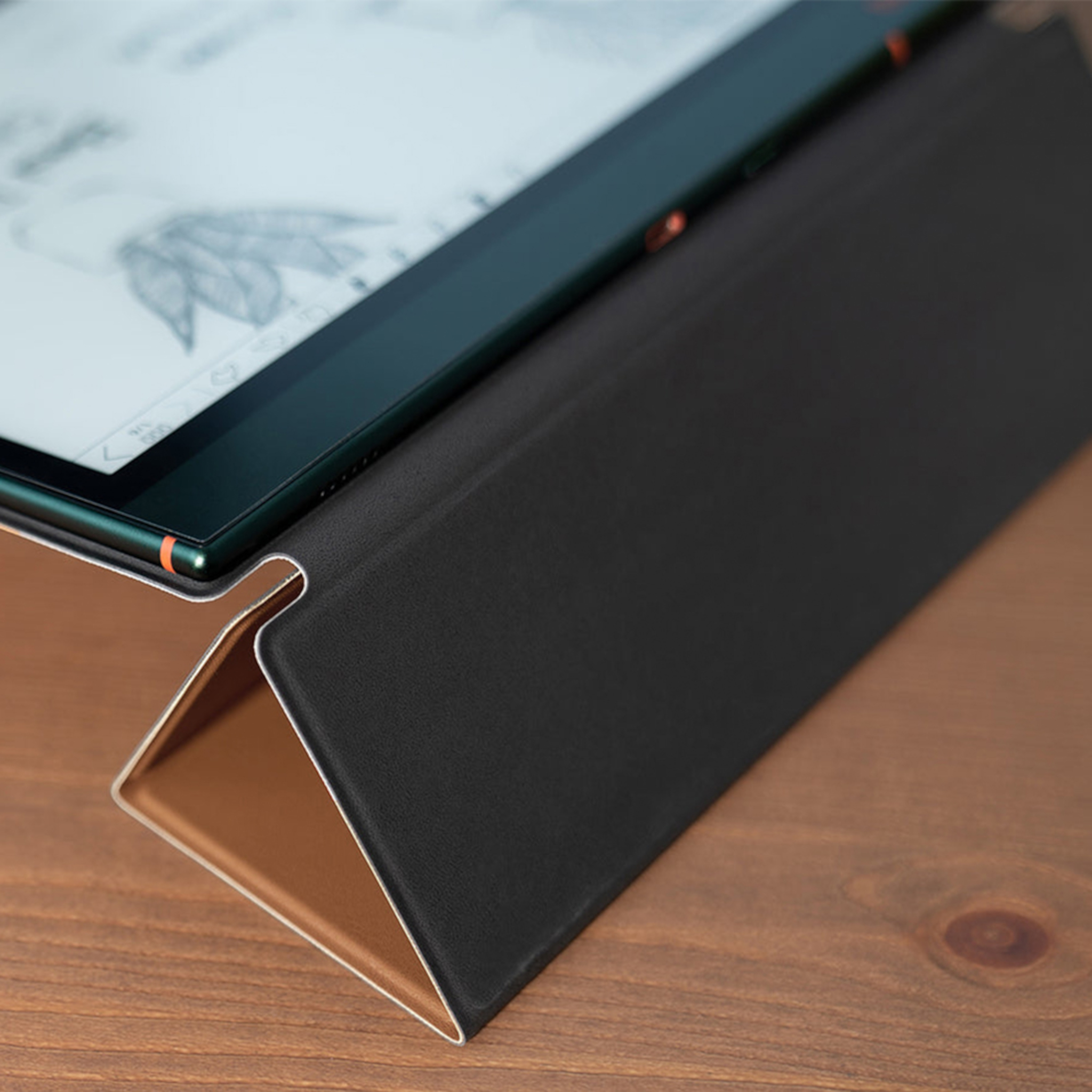 Tablet mit schwarzer Hülle auf Holzoberfläche. Der Bildschirm zeigt eine Zeichnung. Die Hülle ist als Ständer gefaltet.
