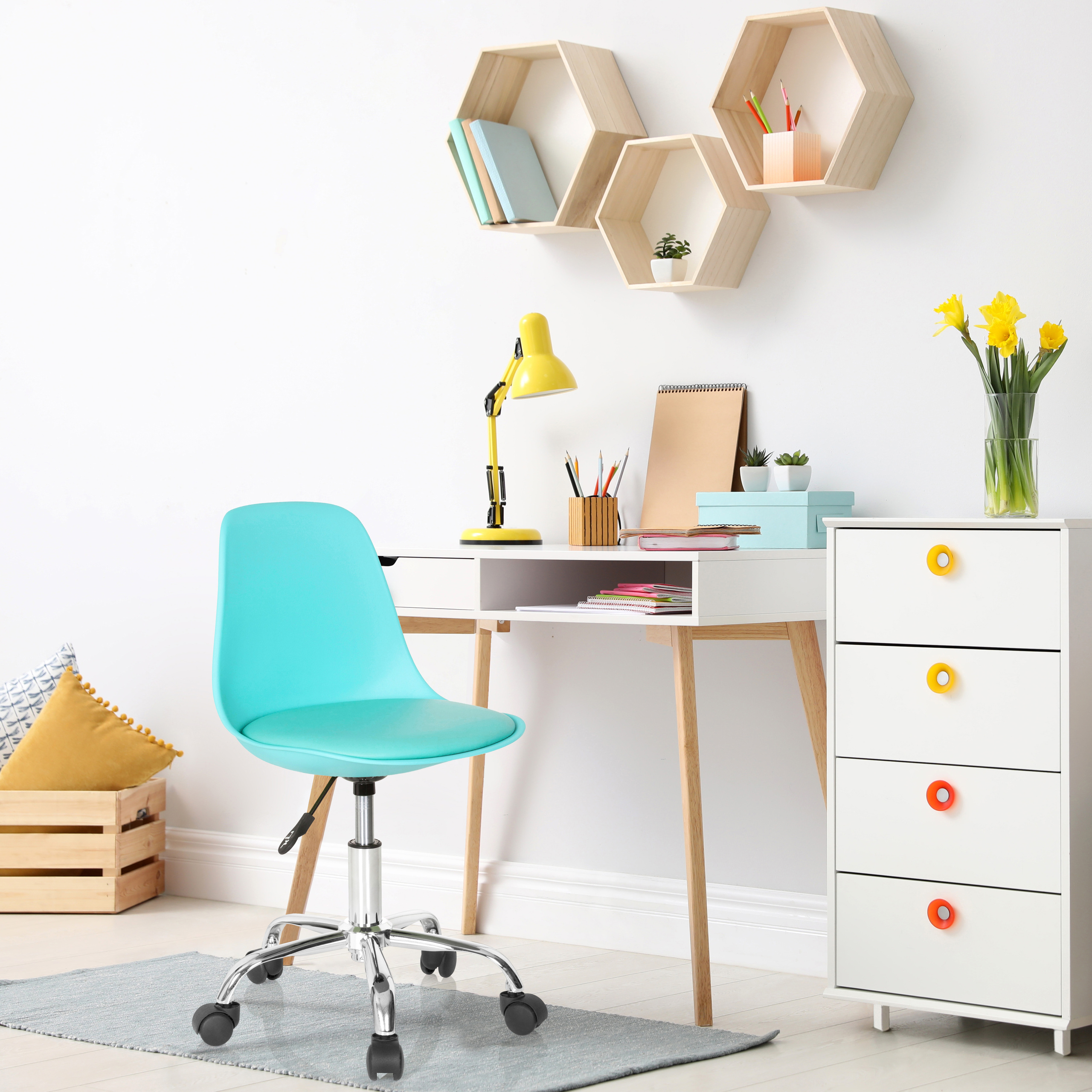 Heller, organisierter Arbeitsbereich mit blauem Stuhl, Schreibtisch und weißem Schrank. Gelbe Lampe, Blumen und sechseckige Regale.