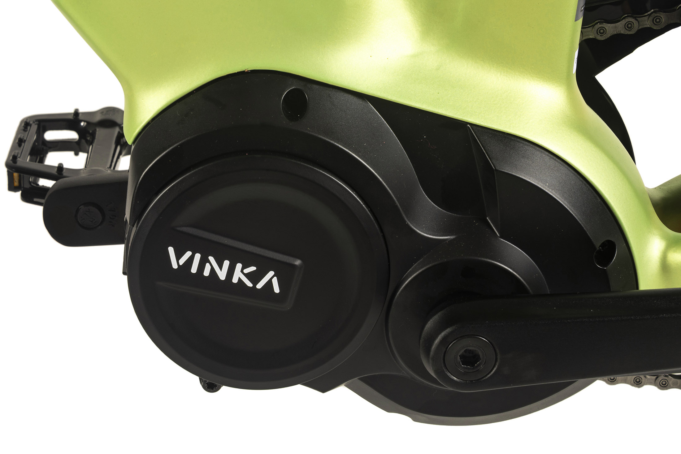 Nahaufnahme eines grünen Fahrradmotors mit schwarzer Abdeckung. Auf der Abdeckung steht das Wort VINKA. Links ist ein Pedal zu sehen.