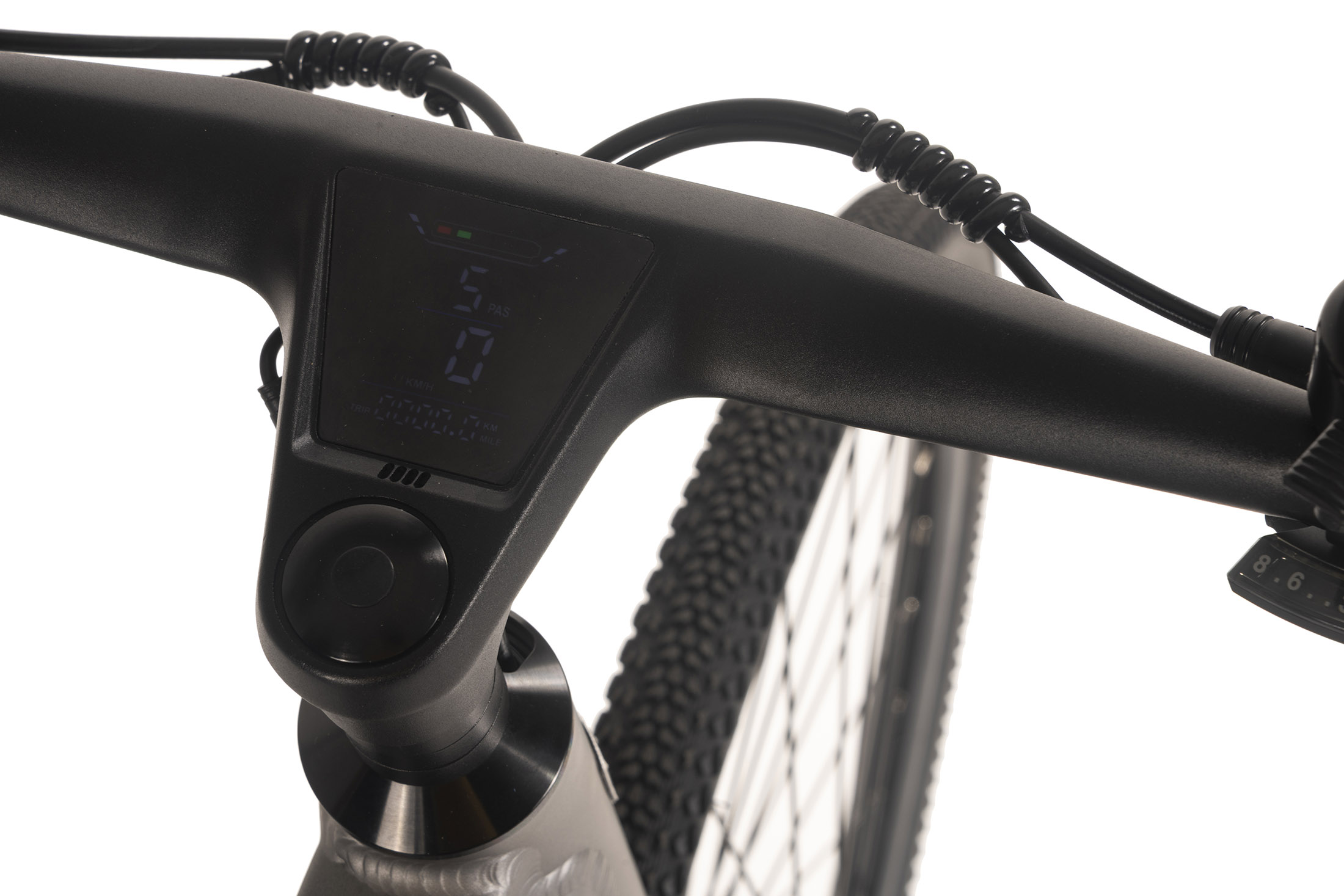 Nahaufnahme eines Fahrradlenkers mit Digitalanzeige. Die Anzeige zeigt Geschwindigkeit und andere Metriken. Im Hintergrund ist ein Reifen zu sehen.