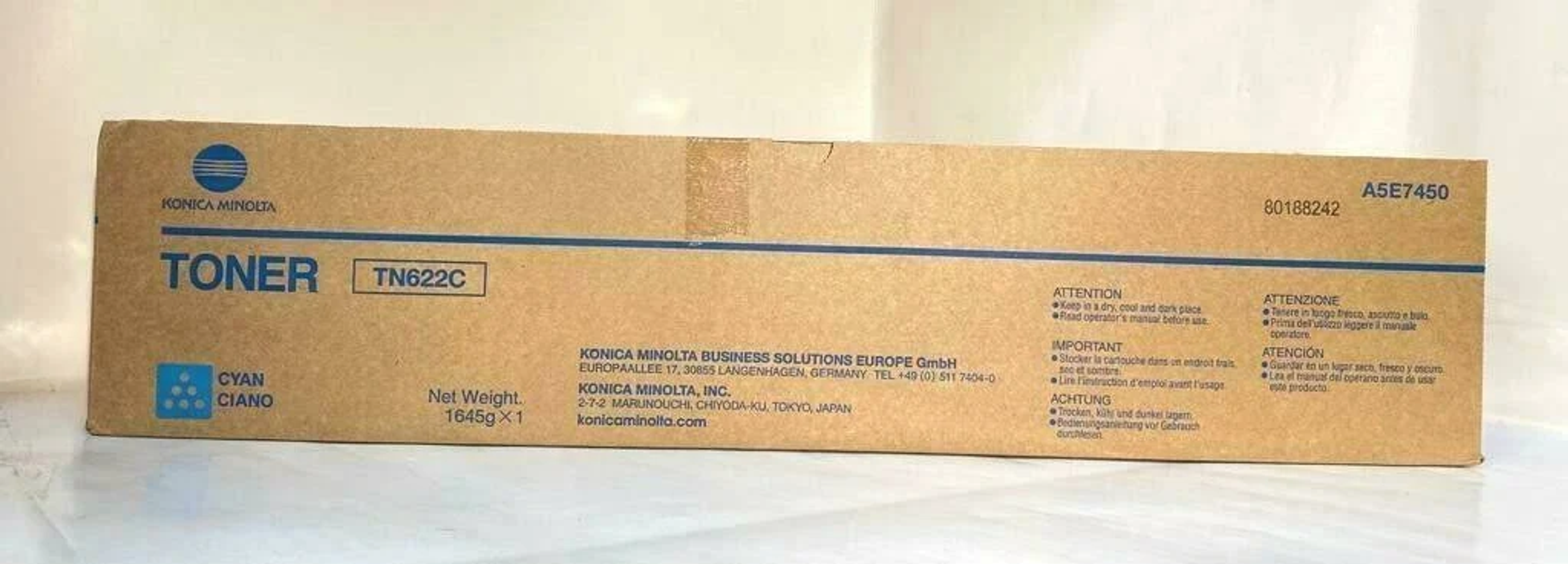 Scatola marrone di toner ciano Konica Minolta TN622C. Testo con dettagli aziendali, prodotto e avvertenze.