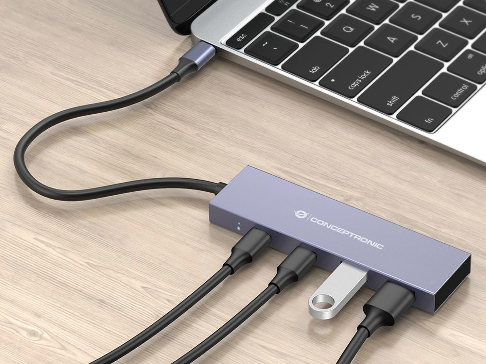 Un laptop collegato a un hub Conceptronic con più porte. È collegata un'unità USB. I cavi sono collegati all'hub.
