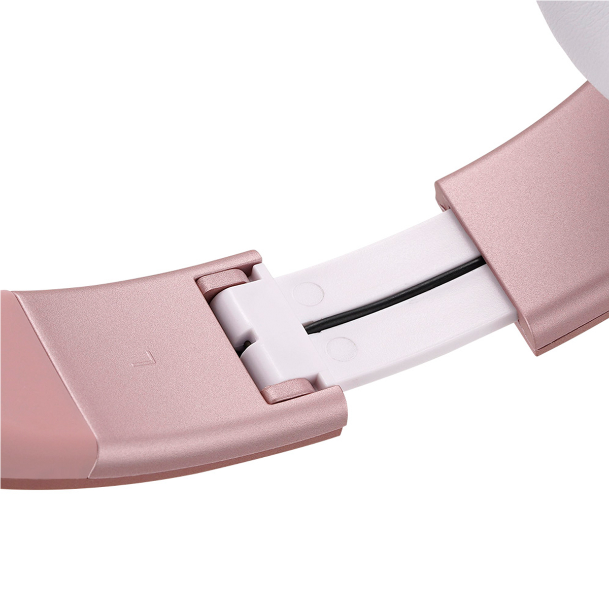 Primo piano di cuffie color oro rosa. Dettagli bianchi e neri. Punto di connessione visibile. Sfondo bianco.