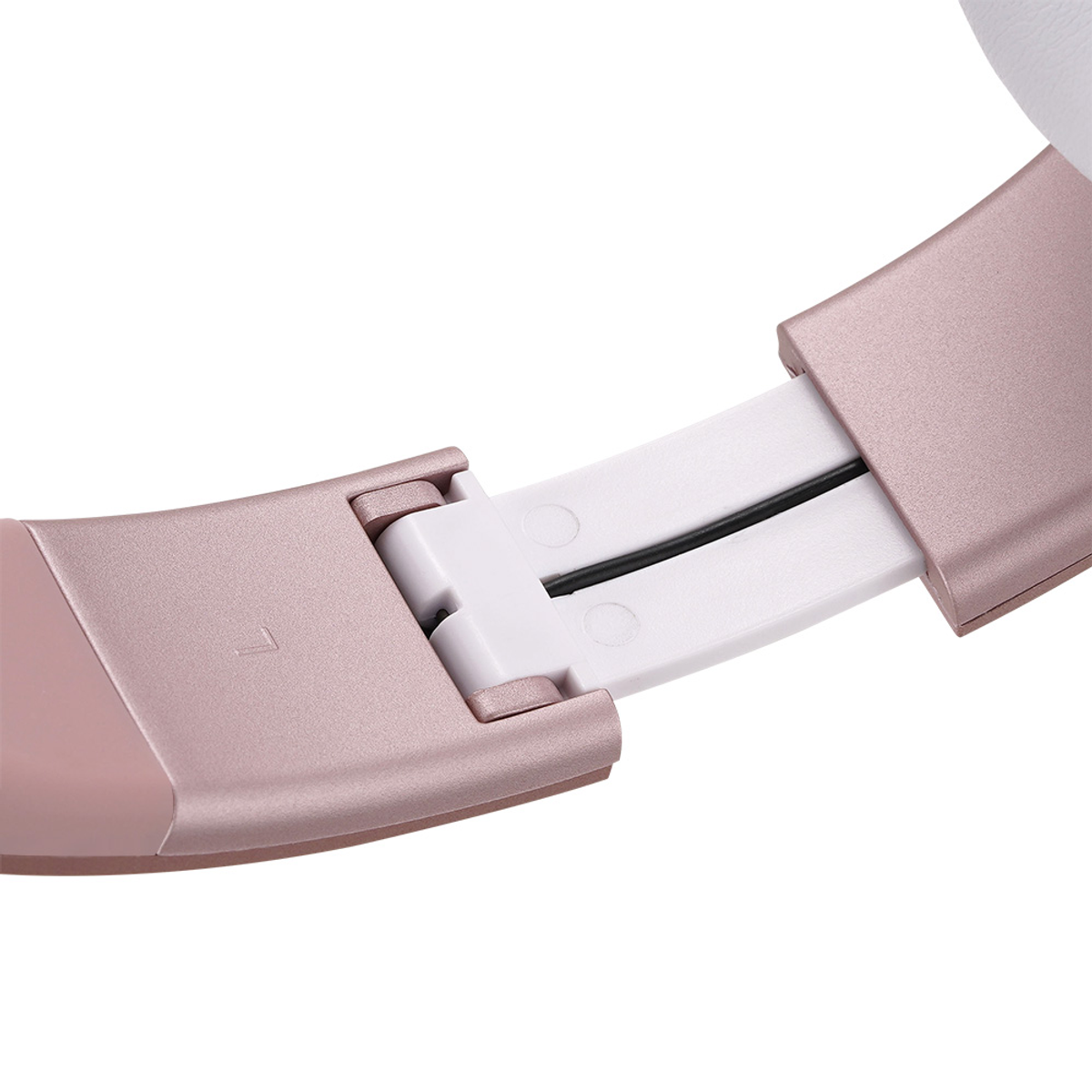 Primo piano della cerniera di cuffie color oro rosa. Mostra un pezzo di plastica bianca, un filo nero e il numero 7. Sfondo bianco.