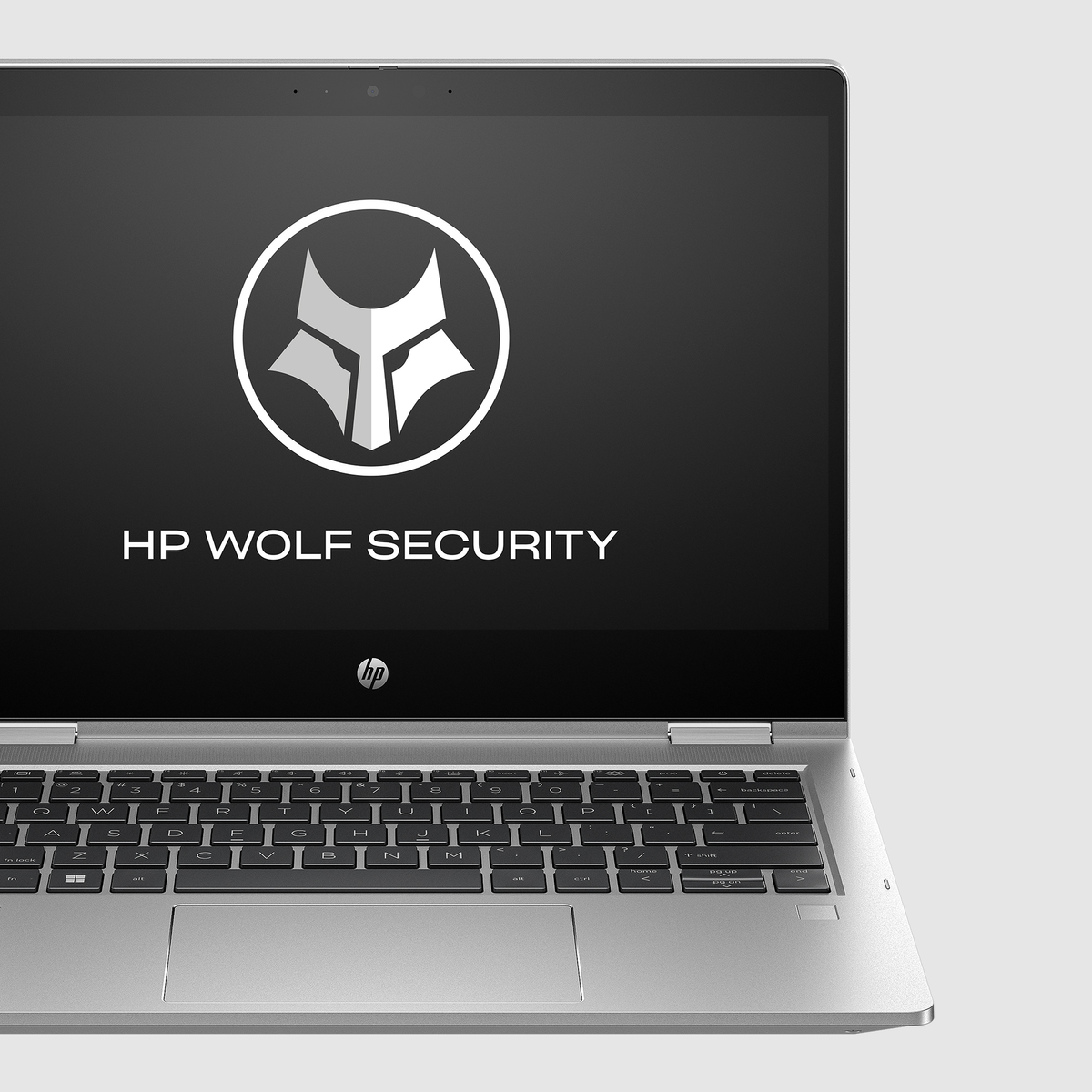 Otwarty srebrny laptop, z logo HP Wolf Security. Klawiatura widoczna, logo HP pod ekranem.