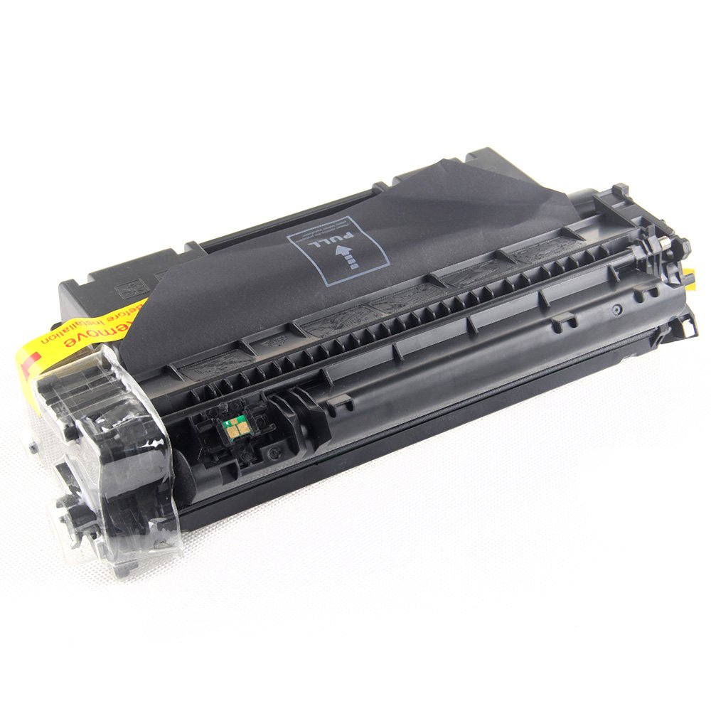 Una cartuccia toner nera con un'etichetta gialla che dice 'rimuovere prima dell'installazione' e una linguetta 'tirare'.
