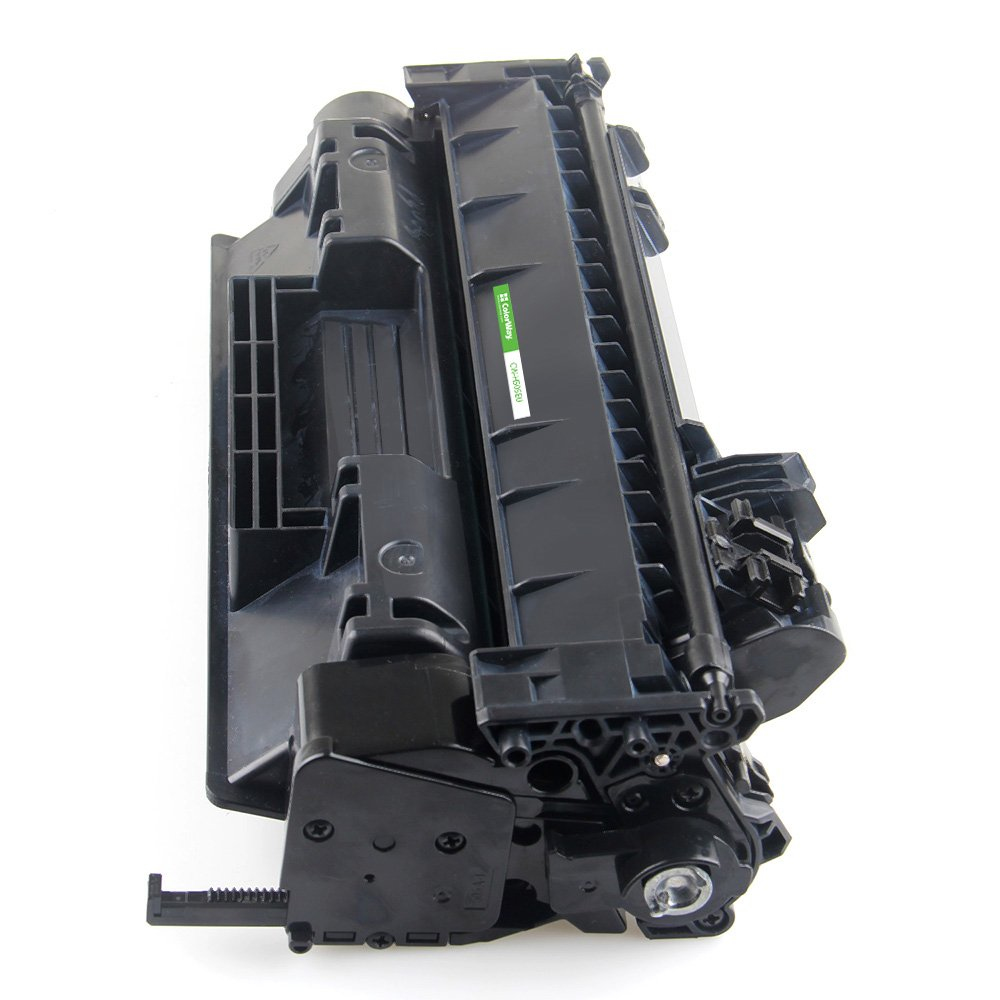 Una cartuccia toner nera per stampante su sfondo bianco. Ha un adesivo verde sul lato. La cartuccia è angolata.