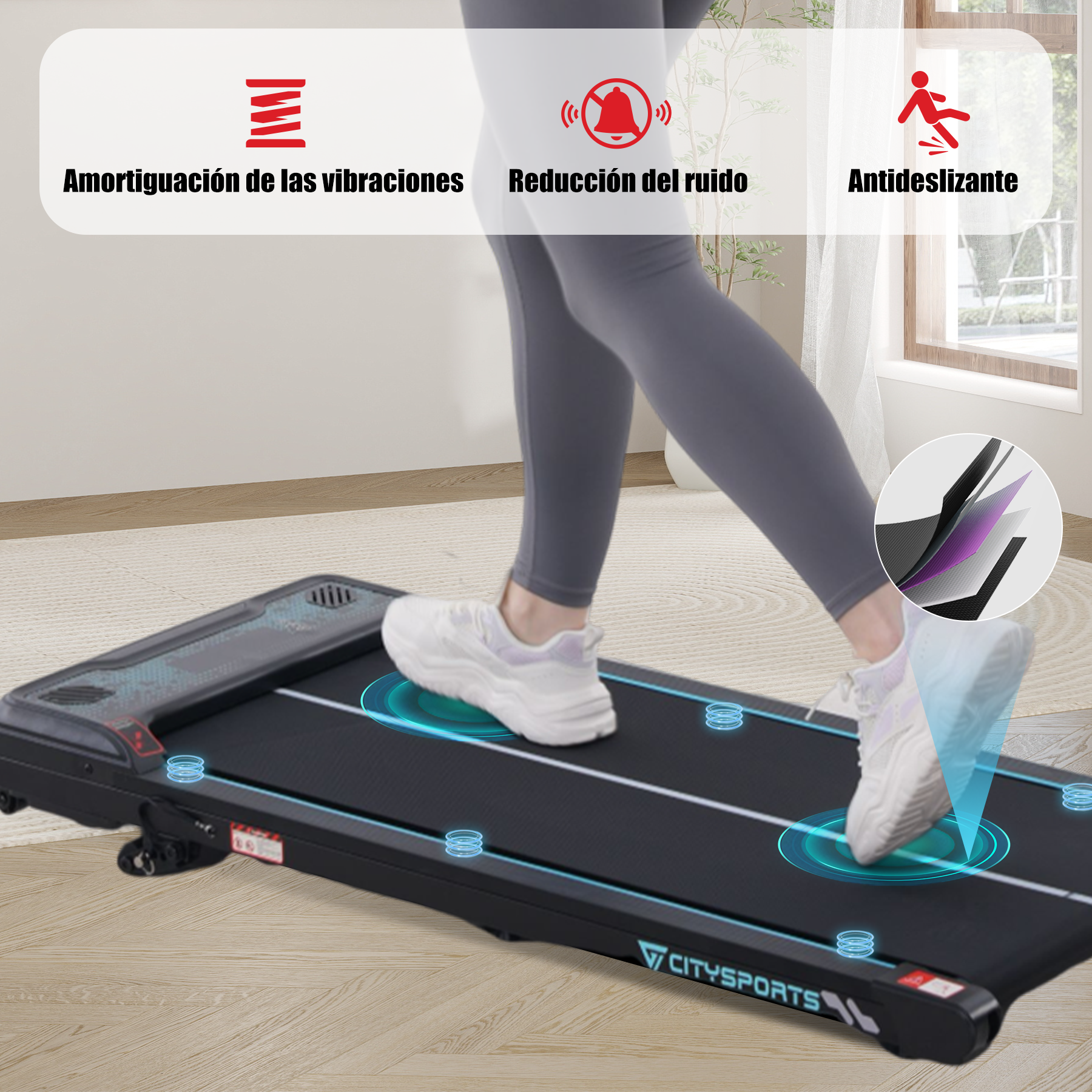 Persona caminando en una cinta de correr. La cinta tiene una superficie negra con círculos azules y el nombre de la marca. El fondo es una habitación.