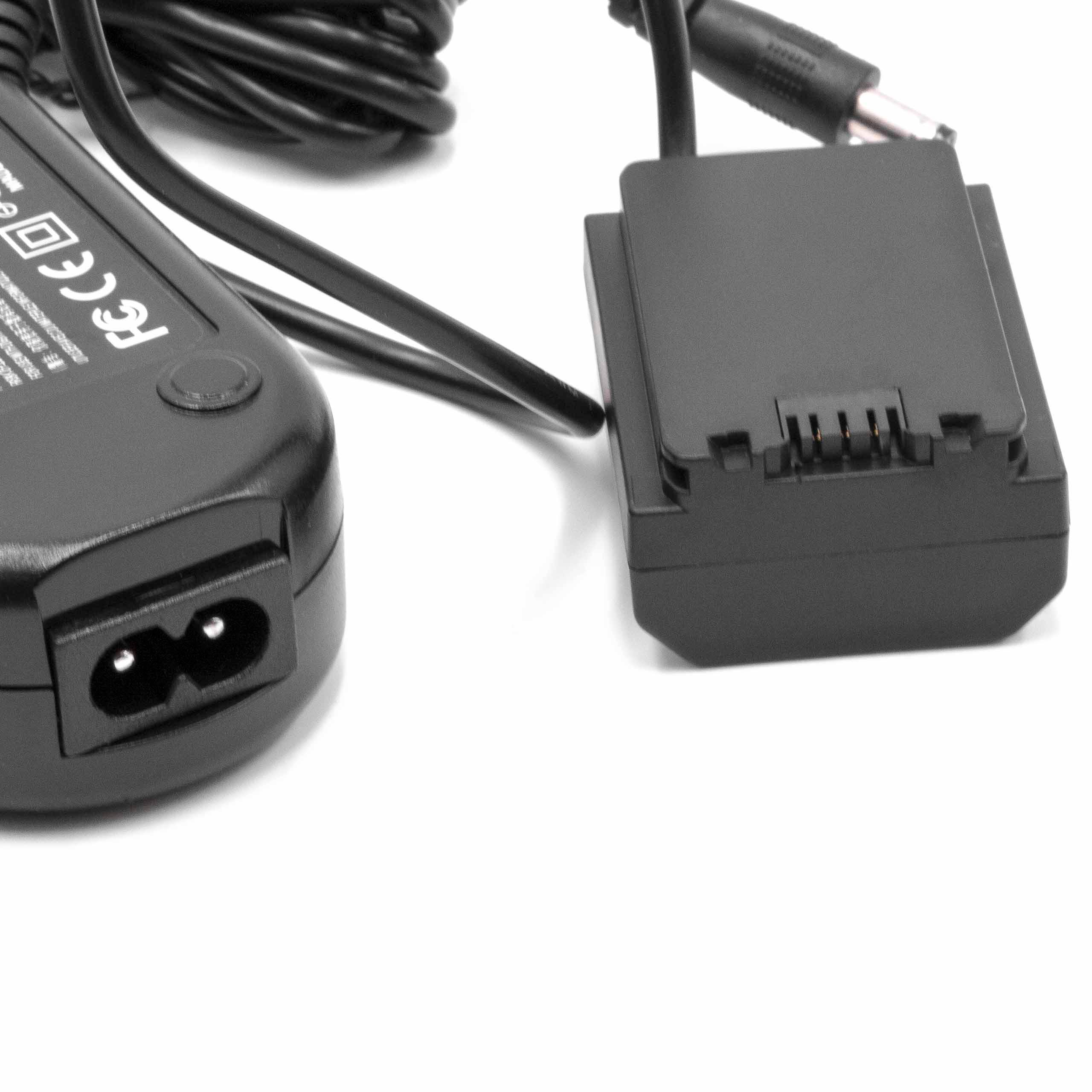 Schwarzes Netzteil mit Netzkabel und Batterieladegerät auf weißer Oberfläche.