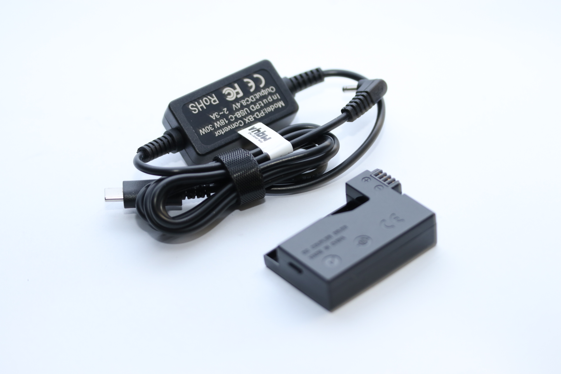 Ein schwarzes Ladegerät mit USB-C-Kabel und ein schwarzer Batterieadapter liegen auf einer weißen Oberfläche.