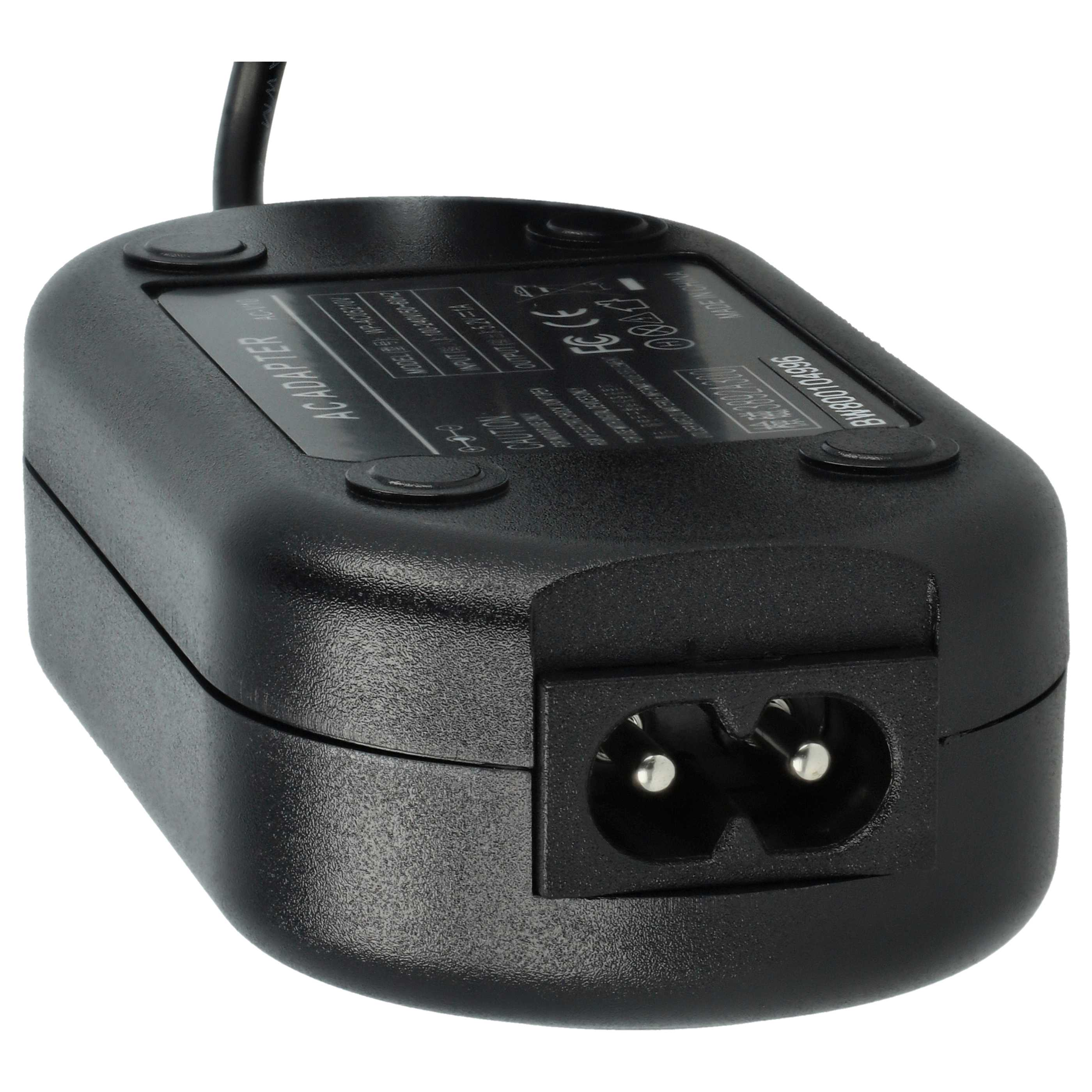 Schwarzer AC-Adapter mit Netzanschluss und Etikett. Oben geht ein schwarzes Kabel ab. Das Etikett hat Text und Markierungen.