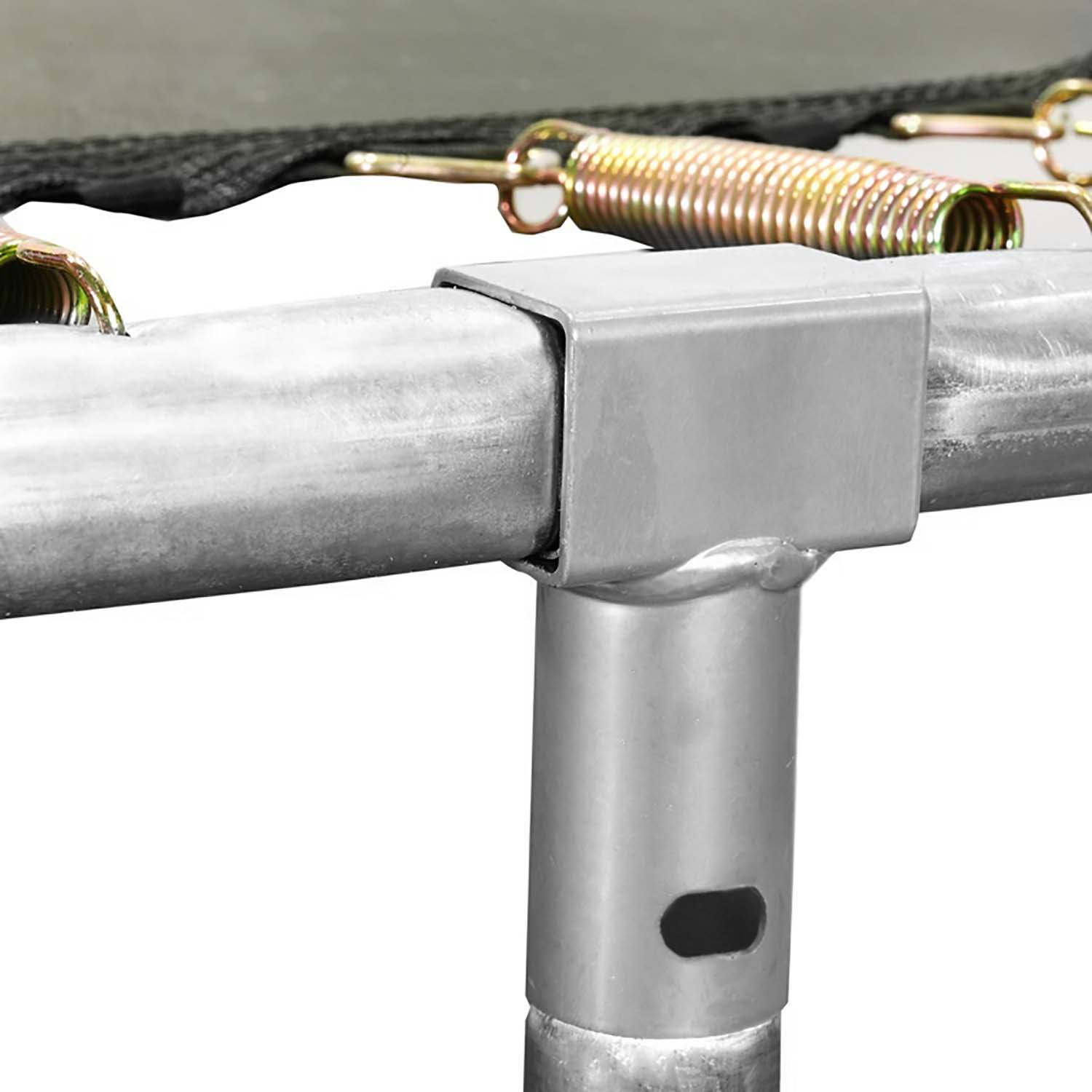 Zbliżenie na połączenie ramy trampoliny. Widoczne srebrne metalowe rury, sprężyna i czarna krawędź materiału na białym tle.