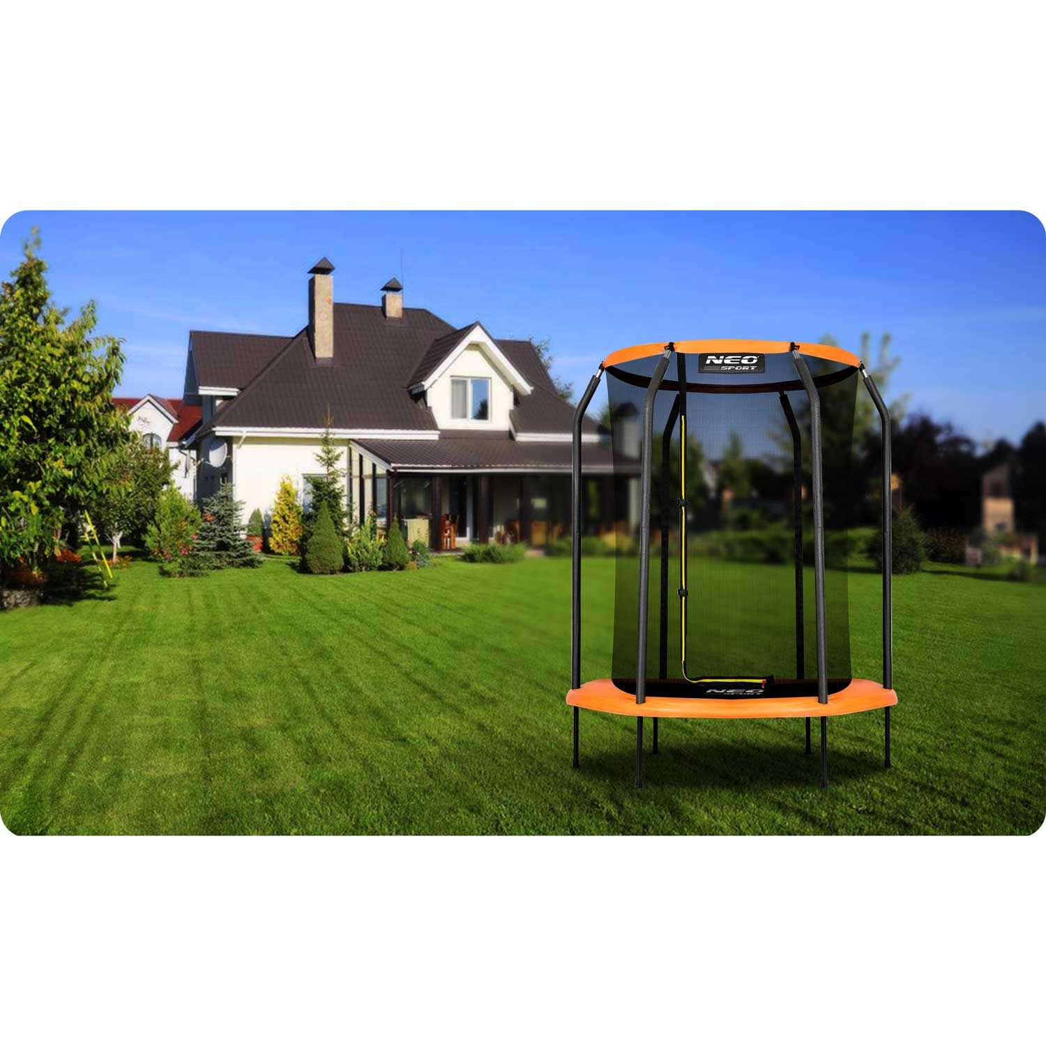 Trampolina na trawniku z domem w tle. Trampolina jest pomarańczowa i czarna.