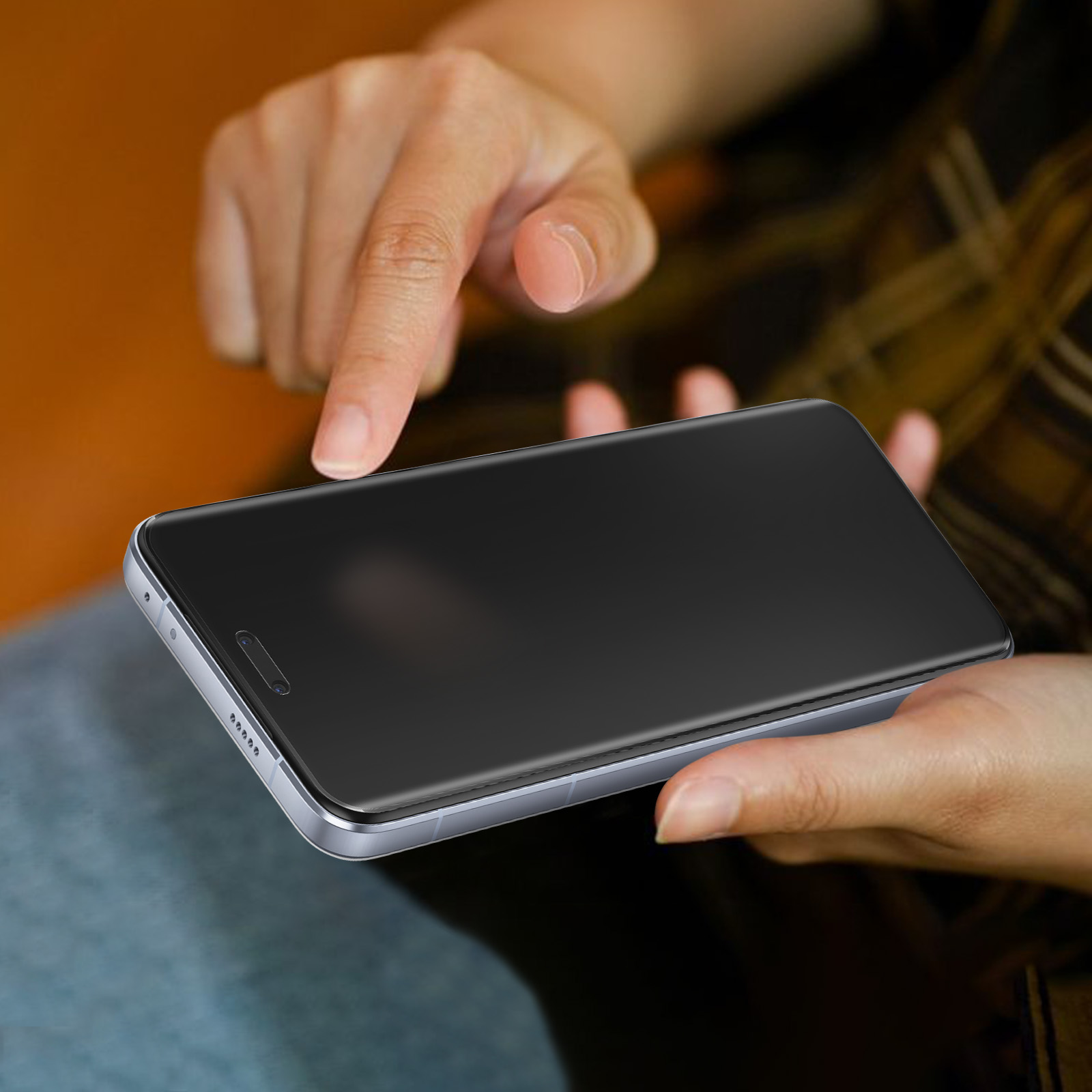 Mani che tengono uno smartphone, dito che tocca lo schermo. Il telefono ha schermo scuro.