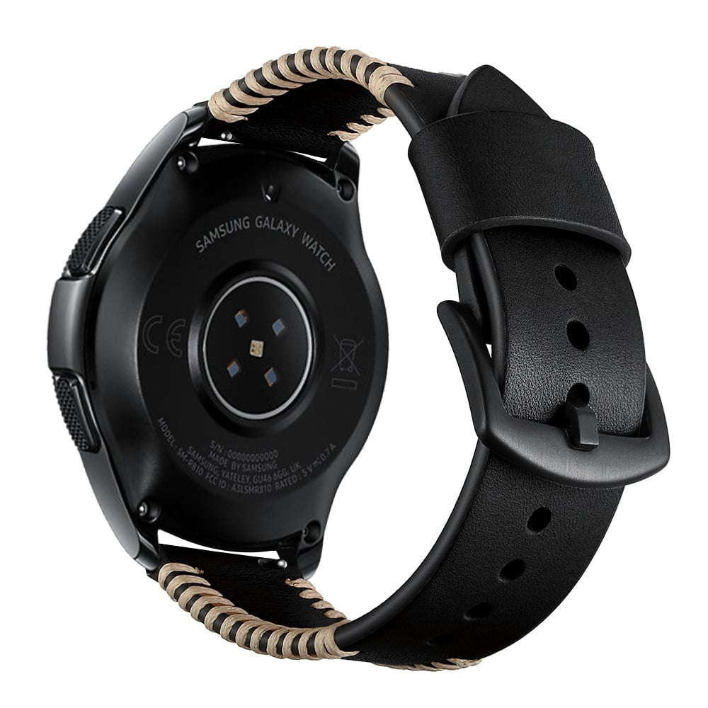 Eine schwarze Samsung Galaxy Watch mit einem schwarzen Lederarmband und einem beige genähten Band. Die Rückseite der Uhr hat Markierungen.