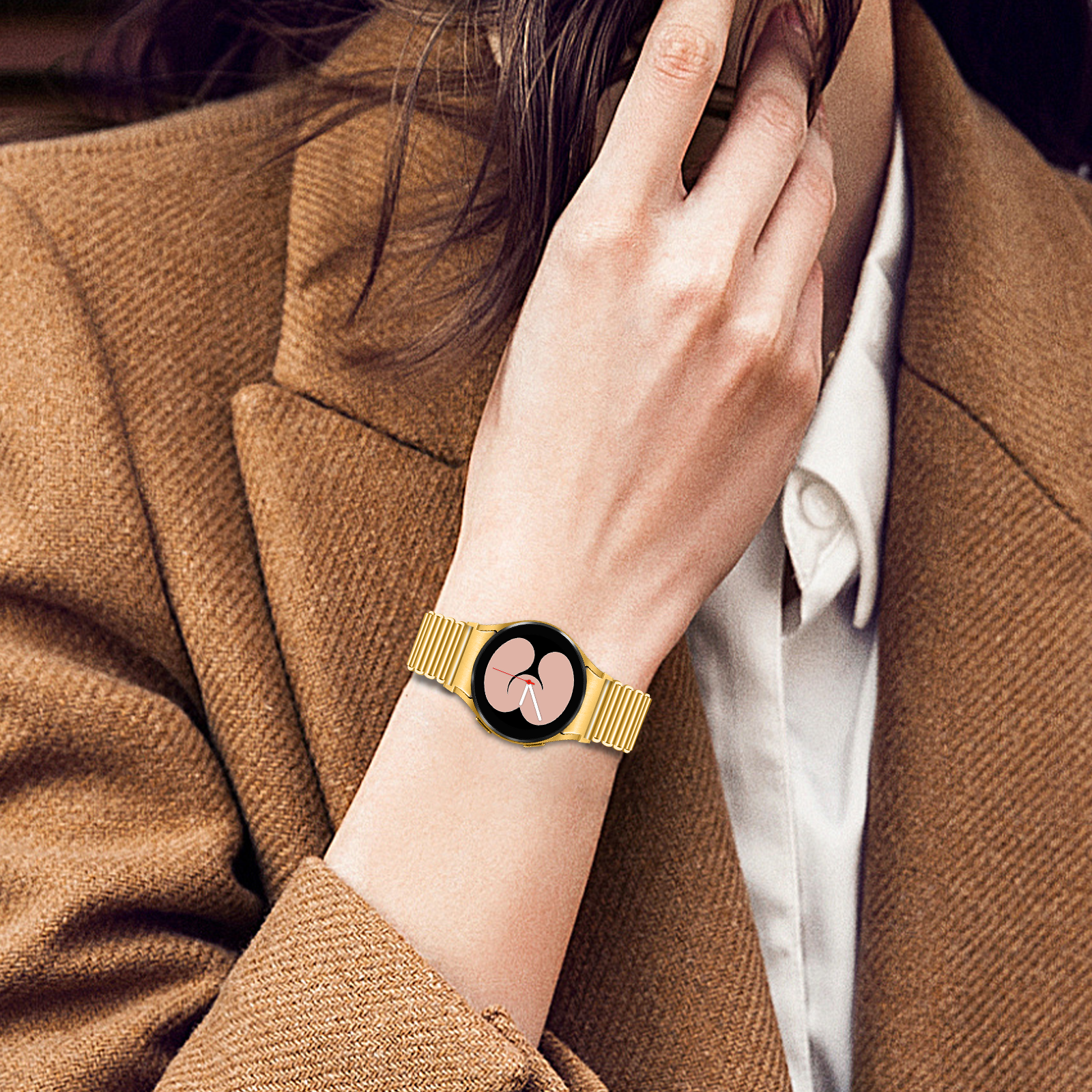 Eine Person berührt ihren Hals. Eine goldene Uhr ist an ihrem Handgelenk. Sie trägt einen braunen Blazer und ein weißes Hemd.