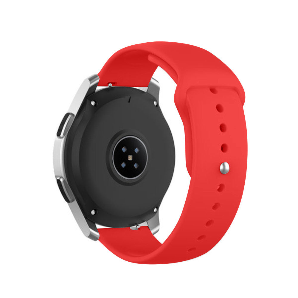 Eine silberne Smartwatch mit schwarzer Unterseite und rotem Armband wird vor weißem Hintergrund gezeigt. Das Armband hat Löcher.