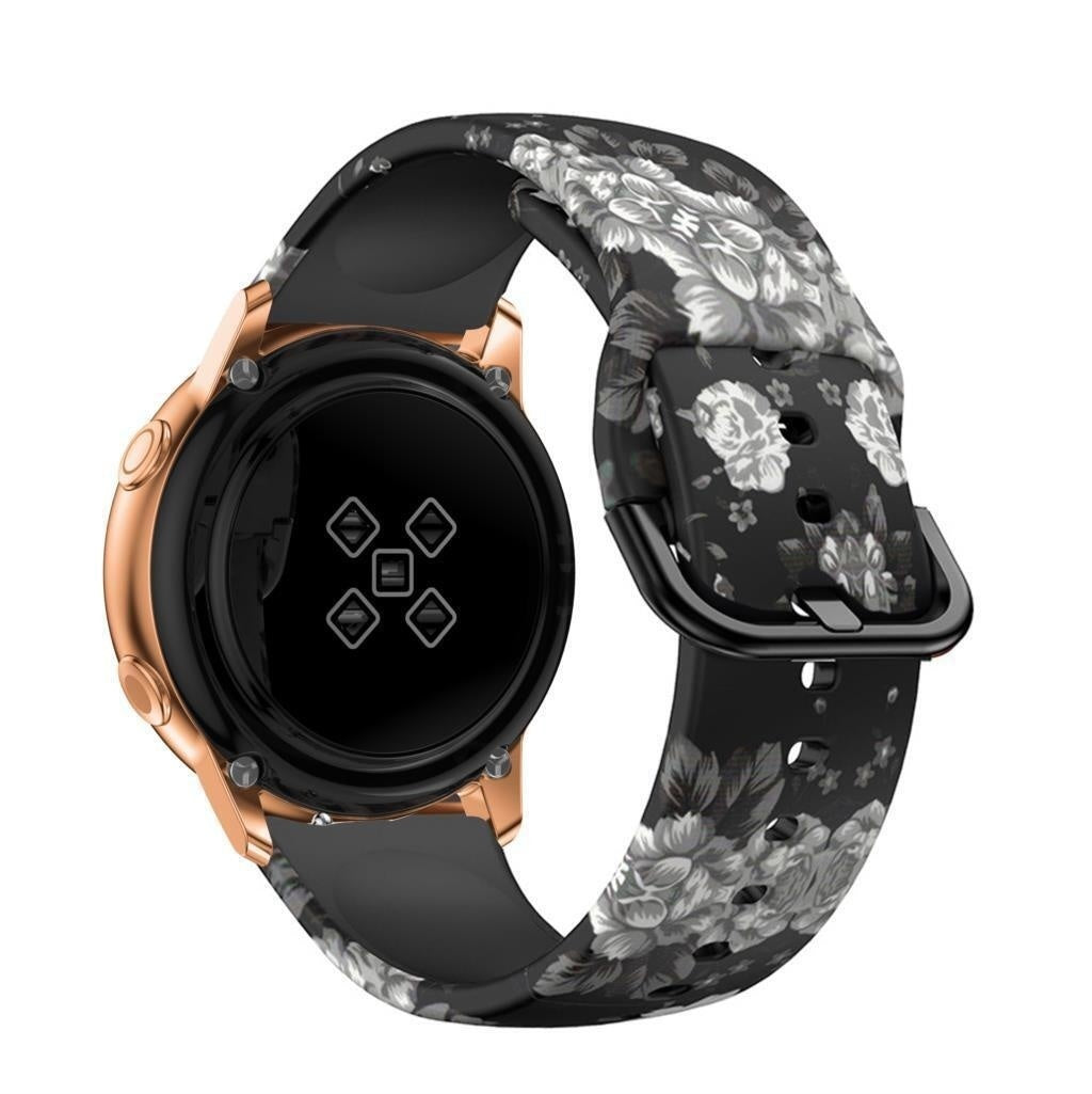 Eine roségoldene Smartwatch mit einem schwarzen Armband mit floralem Muster. Das Band zeigt graue und weiße Blumen auf schwarzem Hintergrund.