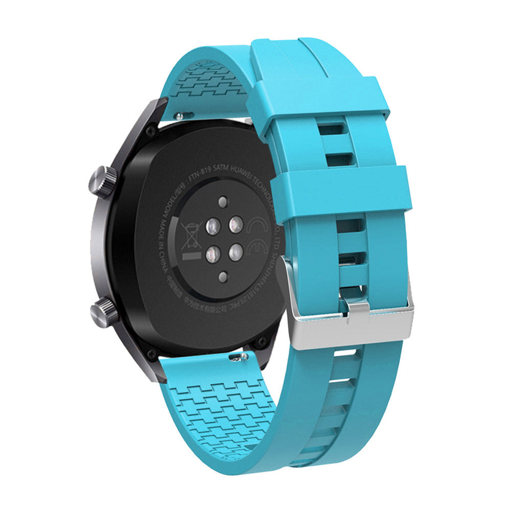 Eine schwarze Smartwatch mit blauem Armband wird gezeigt. Das Armband ist mit dem Gehäuse verbunden, die Schließe ist sichtbar.