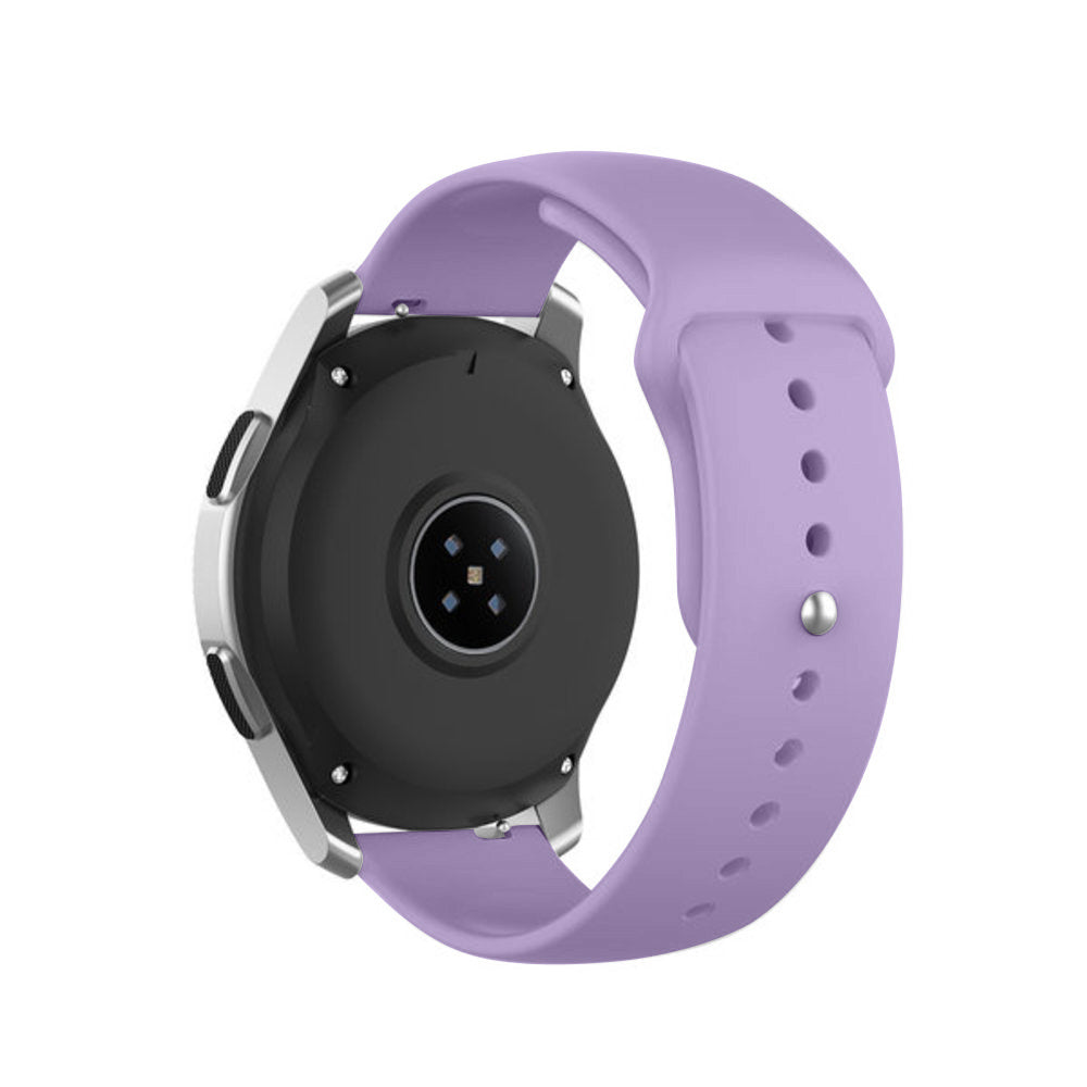 Eine Smartwatch mit einem helllila Armband wird gezeigt. Die Uhr ist schwarz und silber. Das Armband hat Löcher und einen Verschluss.