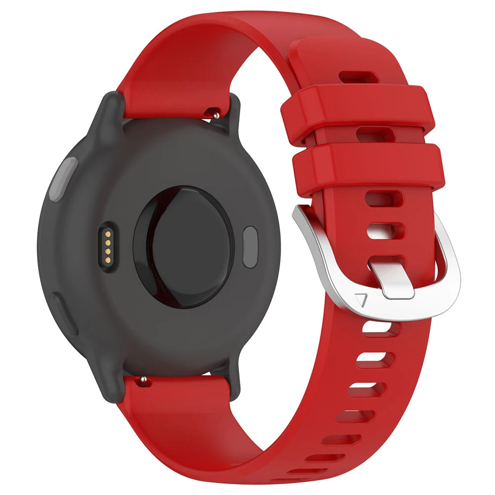 Schwarze Smartwatch mit rotem Armband. Das Armband hat eine silberne Schnalle. Die Rückseite der Uhr hat Ladepins und einen Sensor.