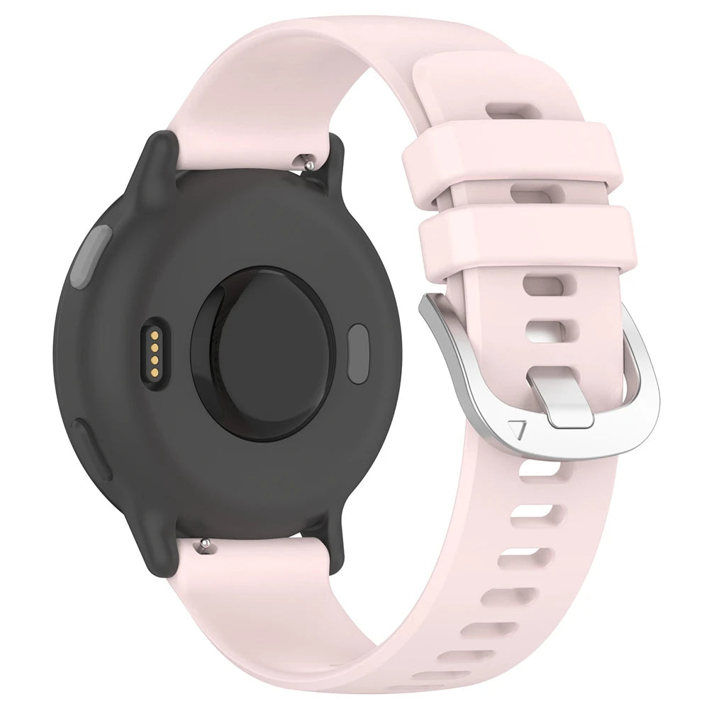 Eine Smartwatch mit schwarzem Gehäuse und hellrosa Armband wird gezeigt. Das Armband hat eine Metallschnalle und die Uhr ist nach unten gerichtet.