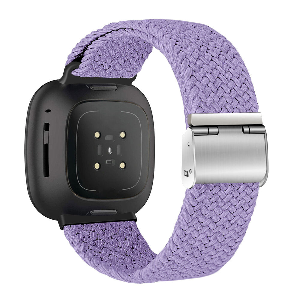 Eine schwarze Smartwatch mit einem lavendelfarbenen geflochtenen Armband. Das Armband hat einen Metallverschluss. Die Uhr hat Sensoren und einen Bildschirm.