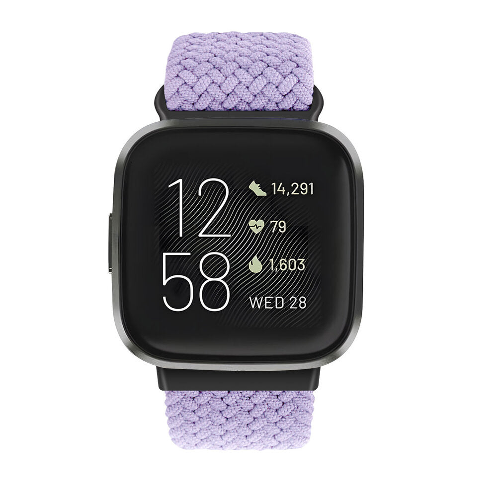 Eine schwarze Smartwatch mit lila gewebtem Armband. Der Bildschirm zeigt Zeit, Schritte, Herzfrequenz und Kalorienverbrauch. Weißer Hintergrund.