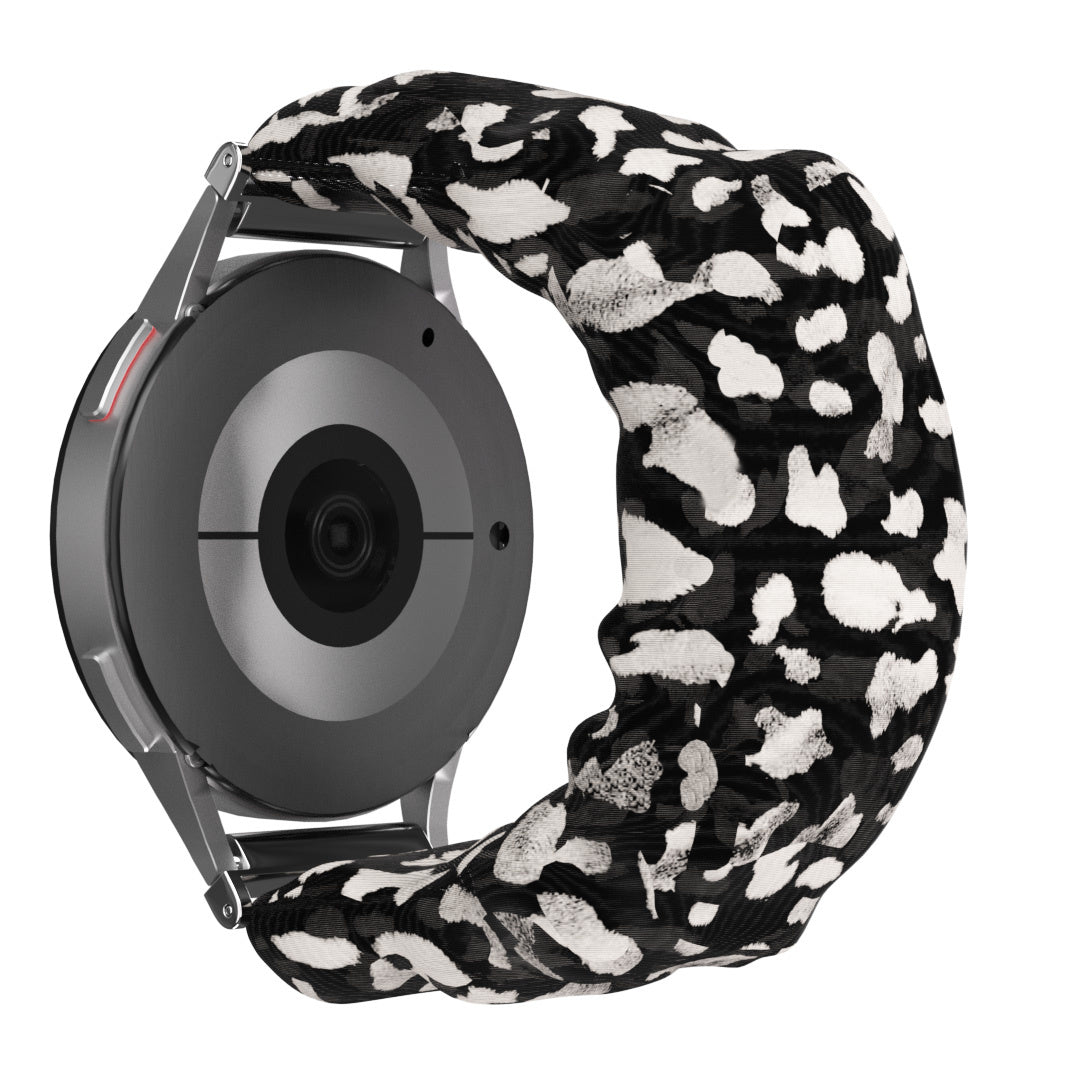 Eine Smartwatch mit einem schwarz-weiß gemusterten Armband. Das Zifferblatt ist grau, das Band hat schwarz-weiße Punkte.