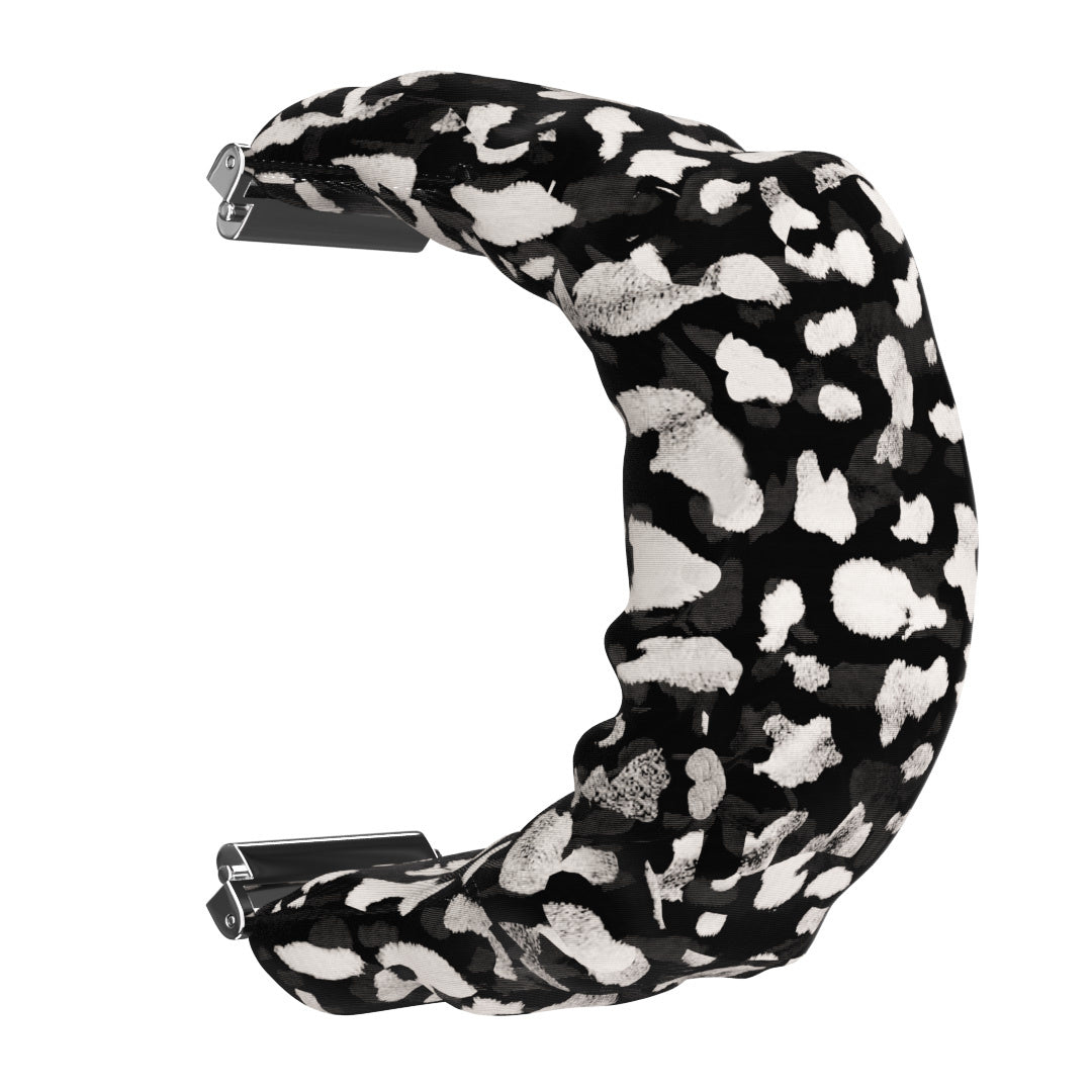Ein schwarz-weiß gemustertes Armband in C-Form, mit Metallverschlüssen an jedem Ende, vor weißem Hintergrund.