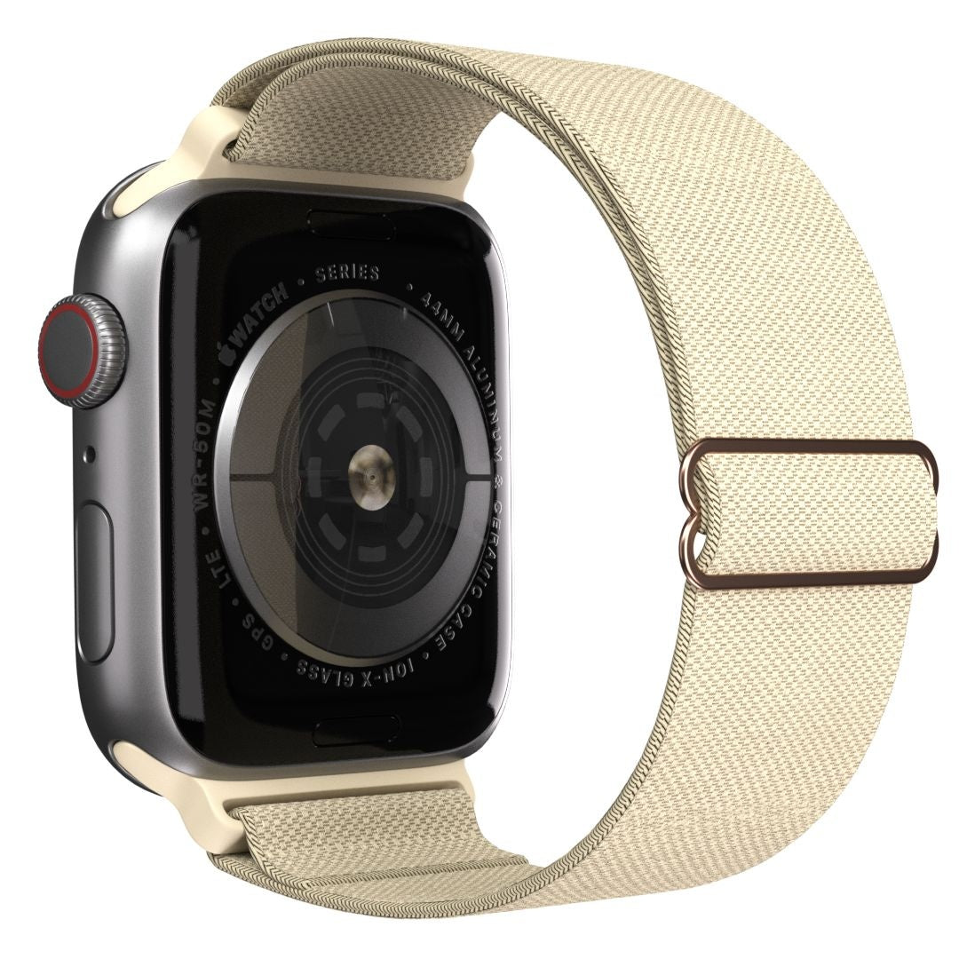 Eine Apple Watch mit beigem Armband wird angezeigt. Die Uhr hat ein silbernes Gehäuse, einen schwarzen Bildschirm und einen roten Knopf.