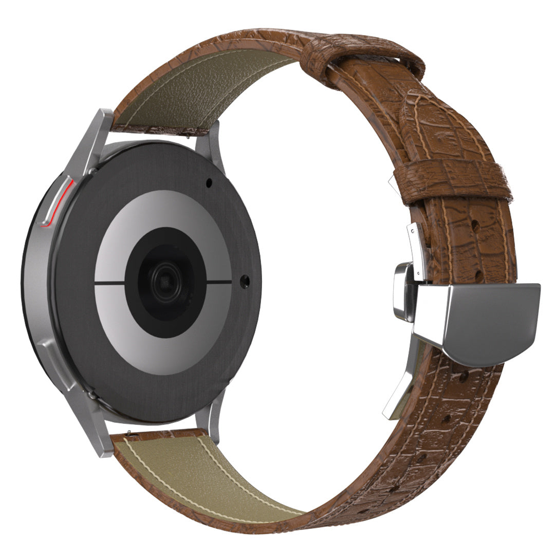 Eine silberne Smartwatch mit braunem Lederarmband. Die Rückseite zeigt einen Sensor. Das Armband hat eine Schnalle.