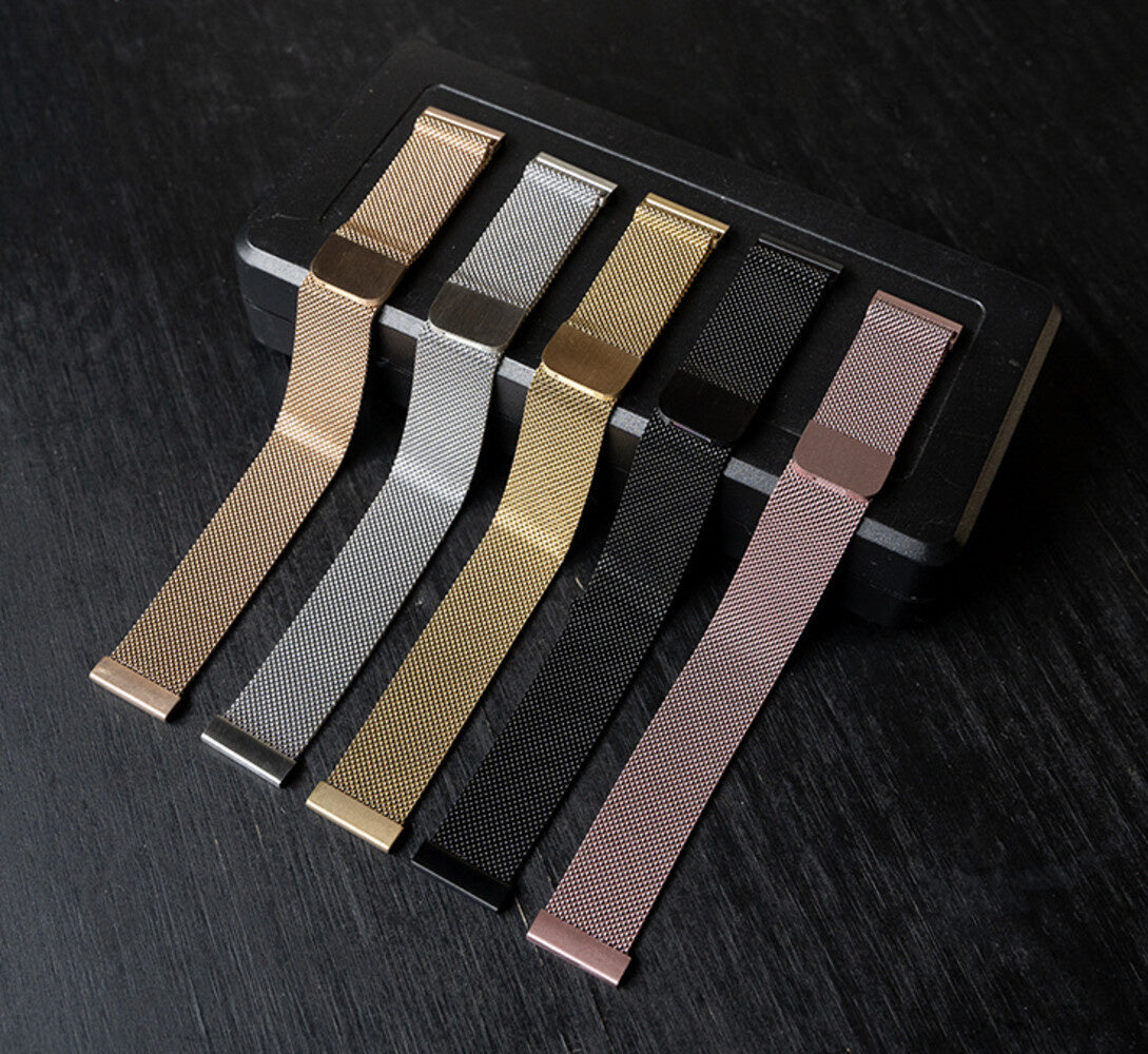 Sechs Metall-Uhrenarmbänder in Gold, Silber und Schwarz, angeordnet auf einer schwarzen Oberfläche. Jedes hat eine andere Farbe.
