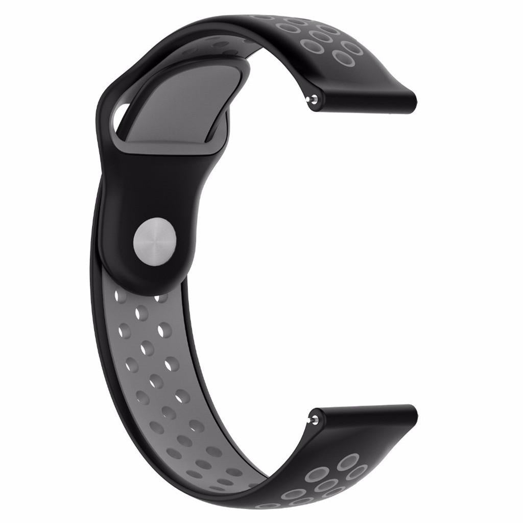 Ein schwarz-graues Armband. Das Band ist C-förmig, aus schwarzem Gummi mit grauem Innenraum. Es hat kleine Löcher.