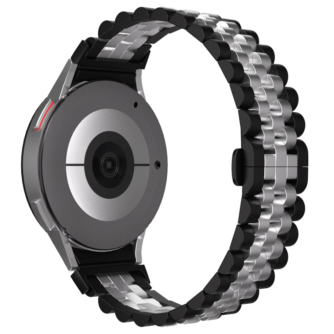 Eine silberne und schwarze Smartwatch mit Metallarmband. Das Zifferblatt ist grau und hat ein Kameraobjektiv. Das Armband ist gebogen.