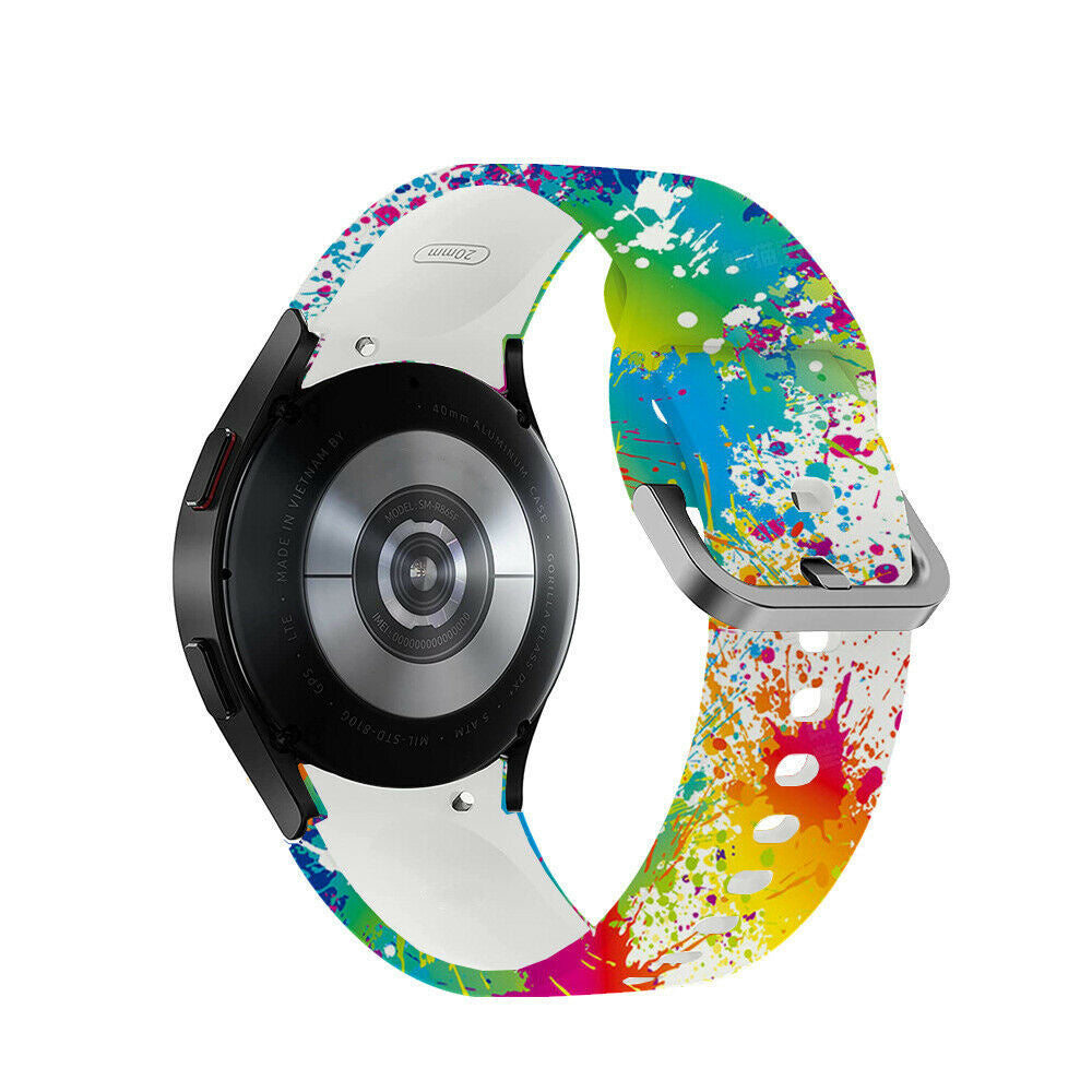 Eine Samsung Smartwatch mit buntem Farbspritzer-Armband. Die Uhr ist schwarz, das Armband weiß mit bunten Farbspritzern.