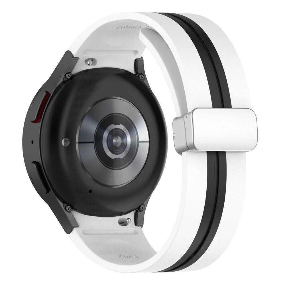 Eine schwarze Smartwatch mit weißem Armband. Das Armband hat schwarze Streifen. Die Uhr liegt auf einer weißen Oberfläche.