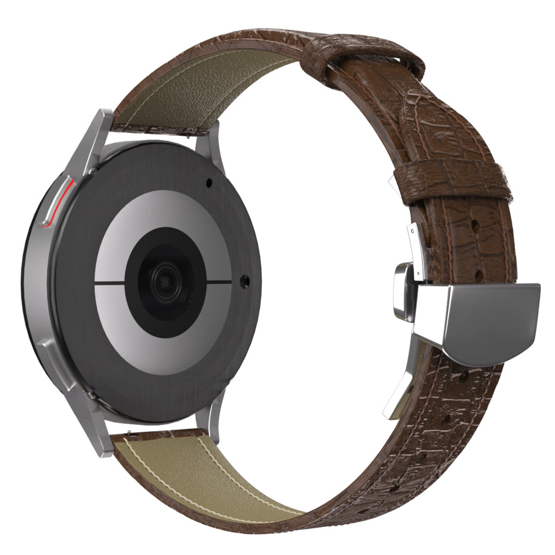 Eine Smartwatch mit braunem Lederarmband und silberner Schließe. Das Zifferblatt ist schwarz mit einer Kamera und einer silbernen Lünette.